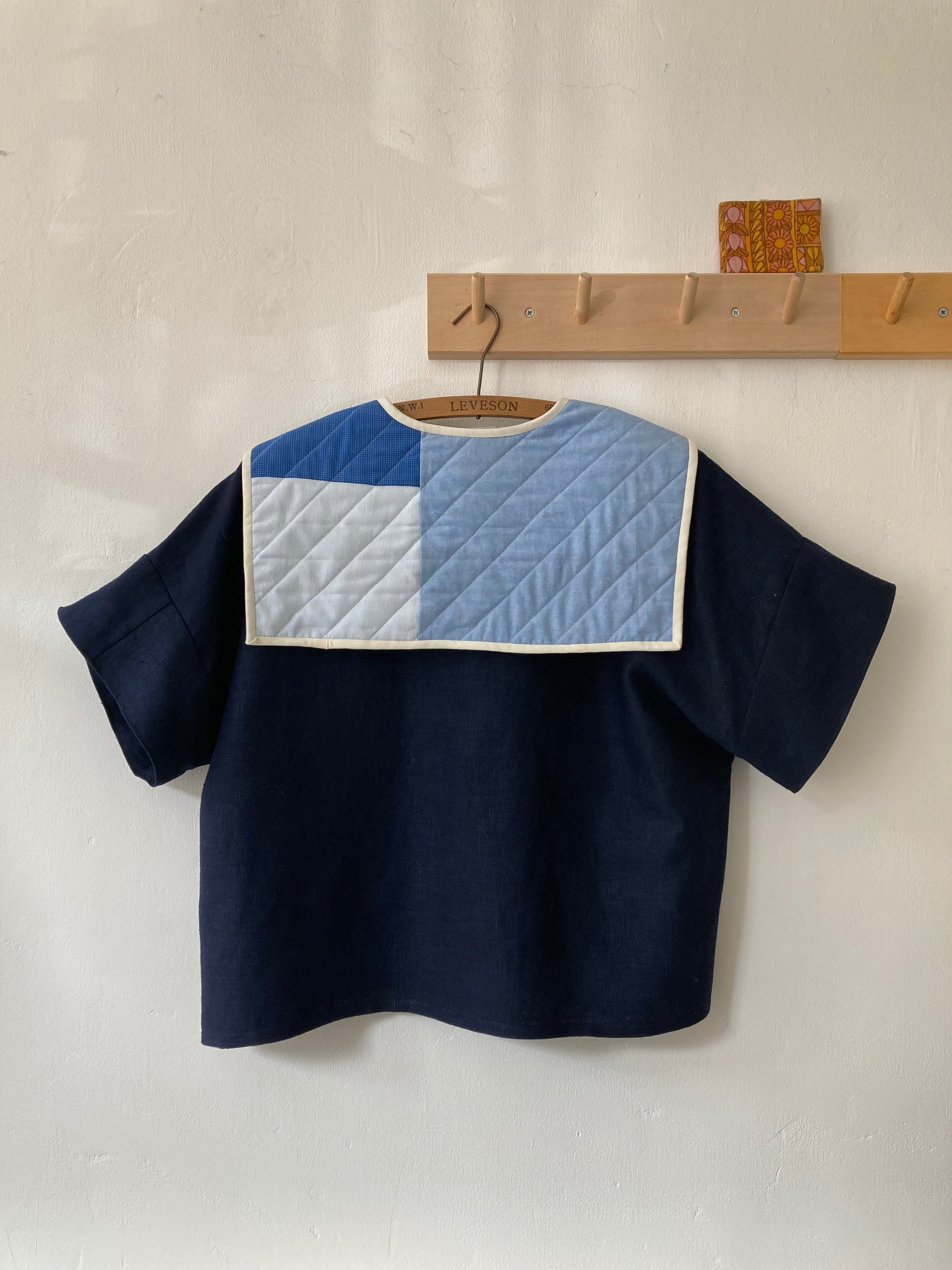 Hand sewn navy blue linen shirt made from reclaimed fabric with a quilted patchwork sailor collar, image shows the back