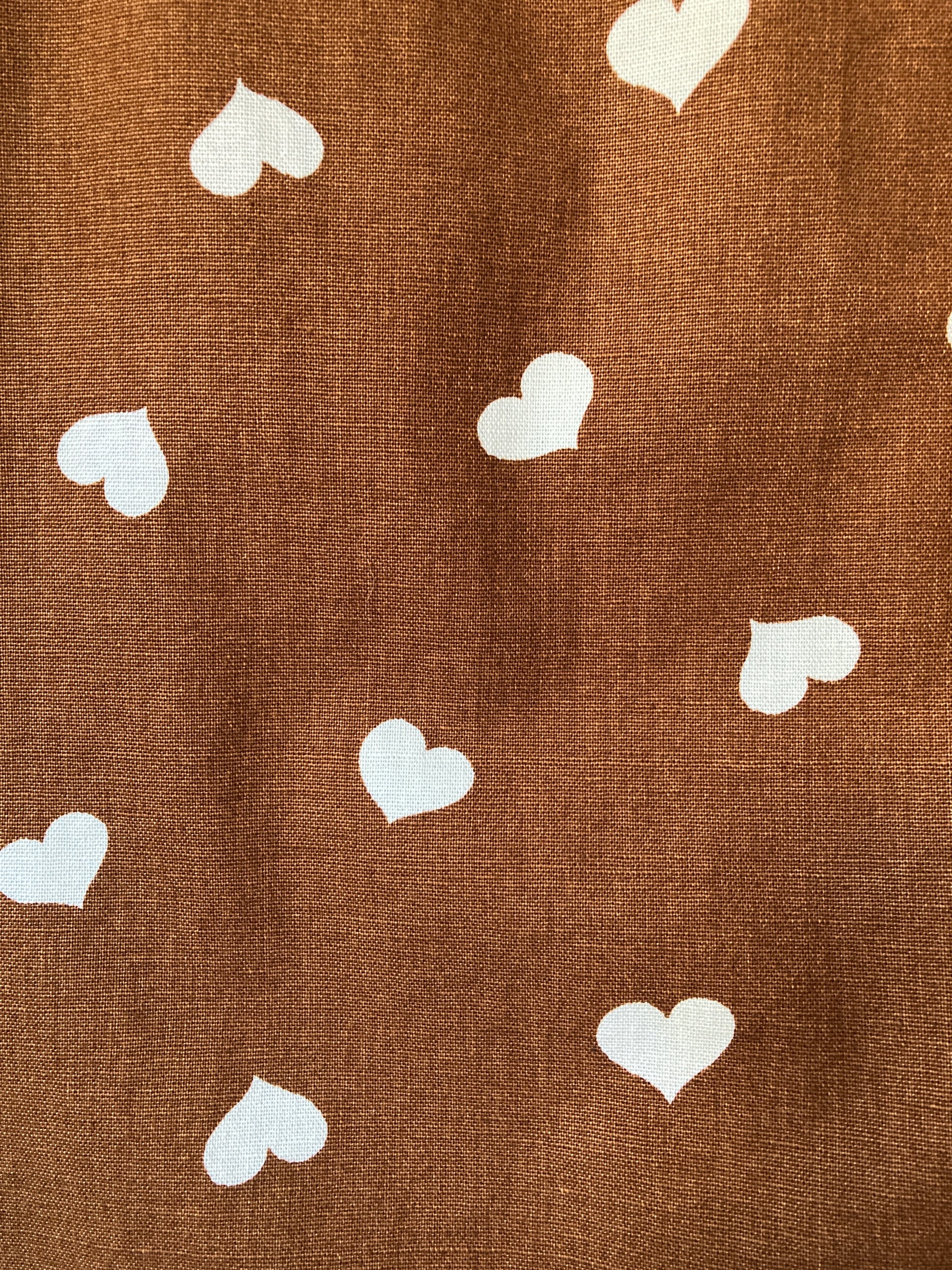 close-up of brown heart-print tie front top made from a recycled tablecloth