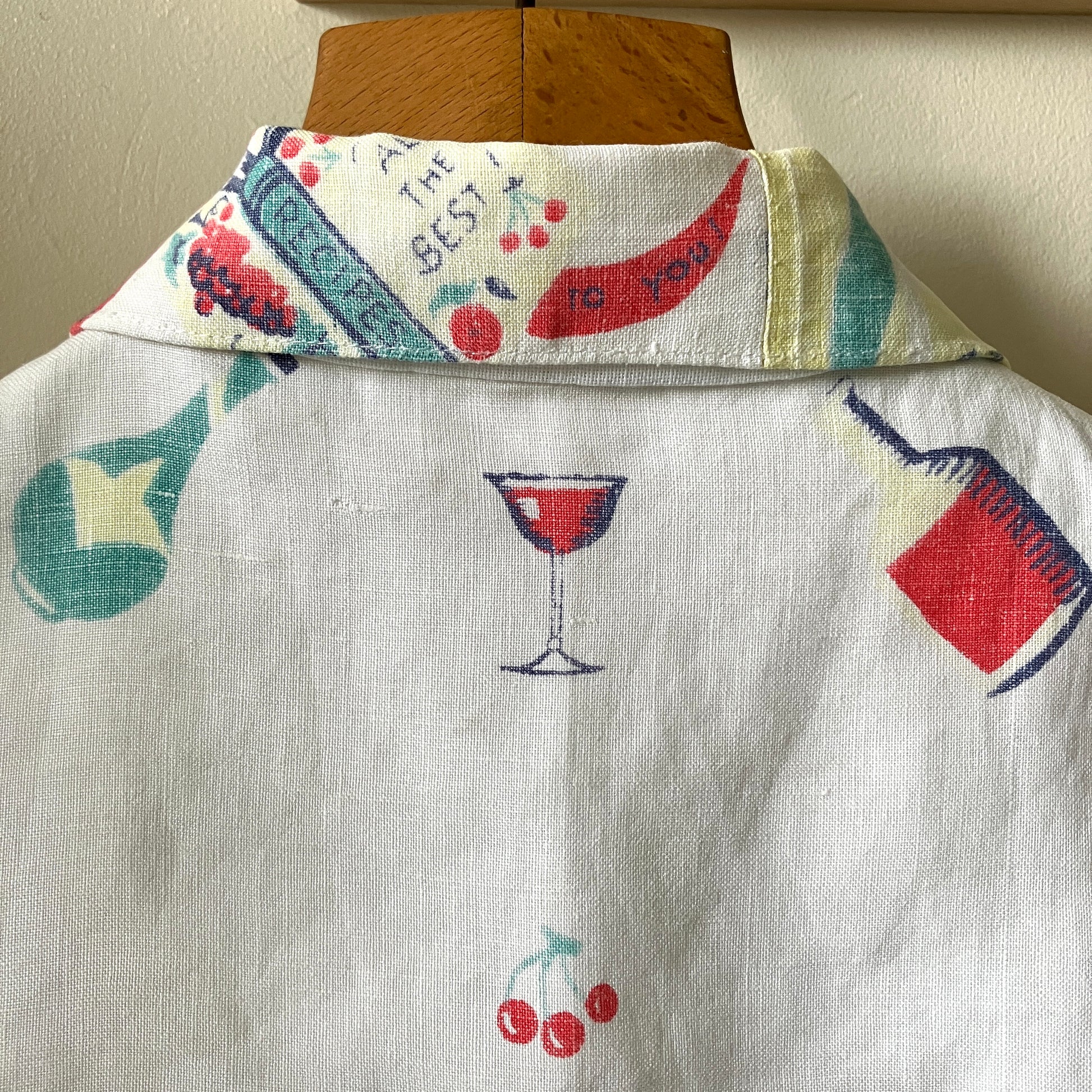 A shirt handmade from a vintage 'cocktails' tablecloth, featuring recipes and illustrations (close-up of back collar)