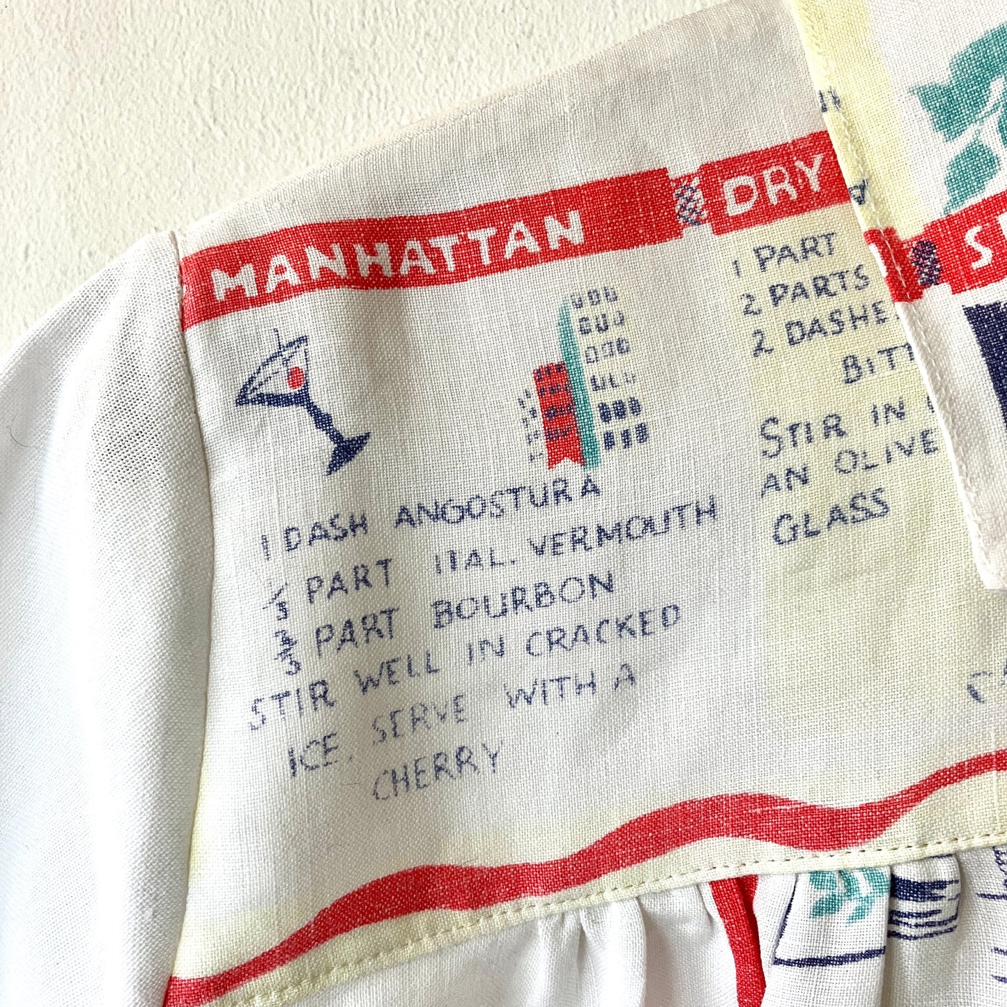 A shirt handmade from a vintage 'cocktails' tablecloth, featuring recipes and illustrations (close-up of recipe for Manhattan)