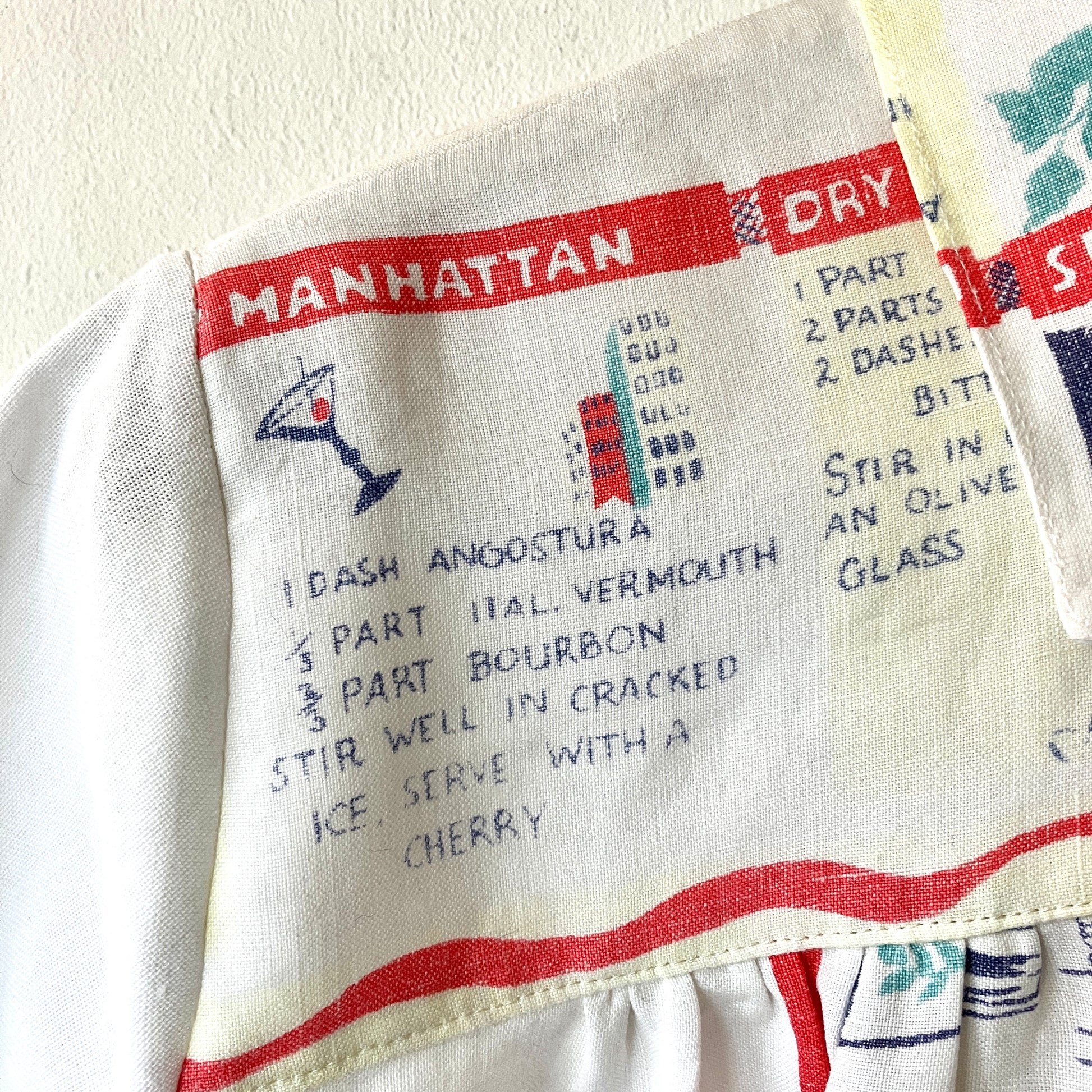 A shirt handmade from a vintage 'cocktails' tablecloth, featuring recipes and illustrations (close-up of recipe for Manhattan)