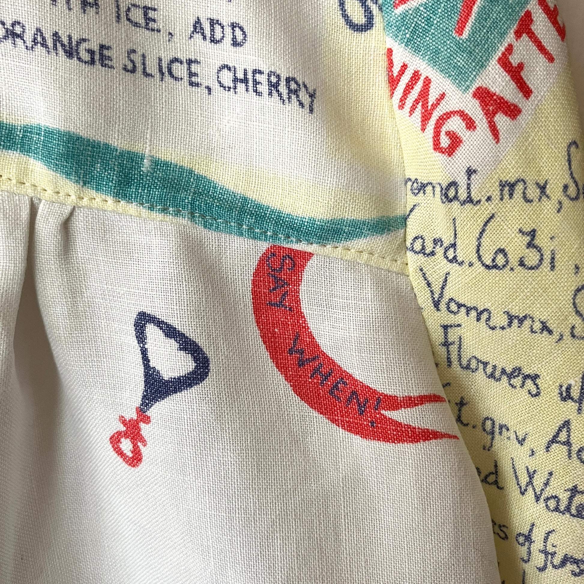 A shirt handmade from a vintage 'cocktails' tablecloth, featuring recipes and illustrations  (close-up of the phrase 'say when!')