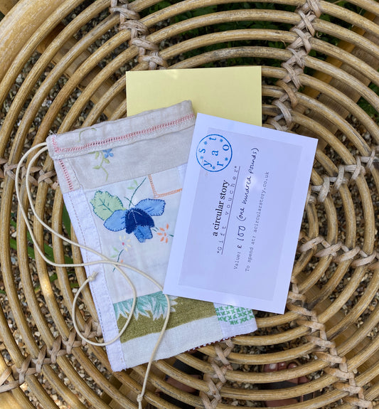 A Circular Story gift voucher alongside a patchwork scrap bag, photographed on a wicker table