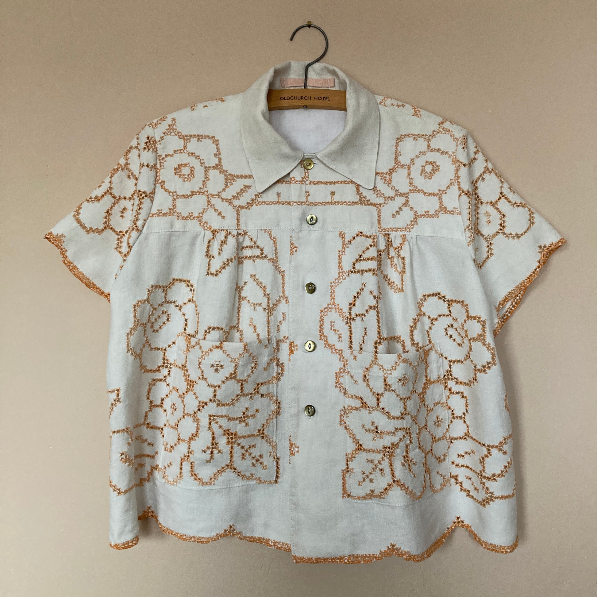 Short-sleeved shirt made from a recycled off-white linen tablecloth with orange cutwork pattern