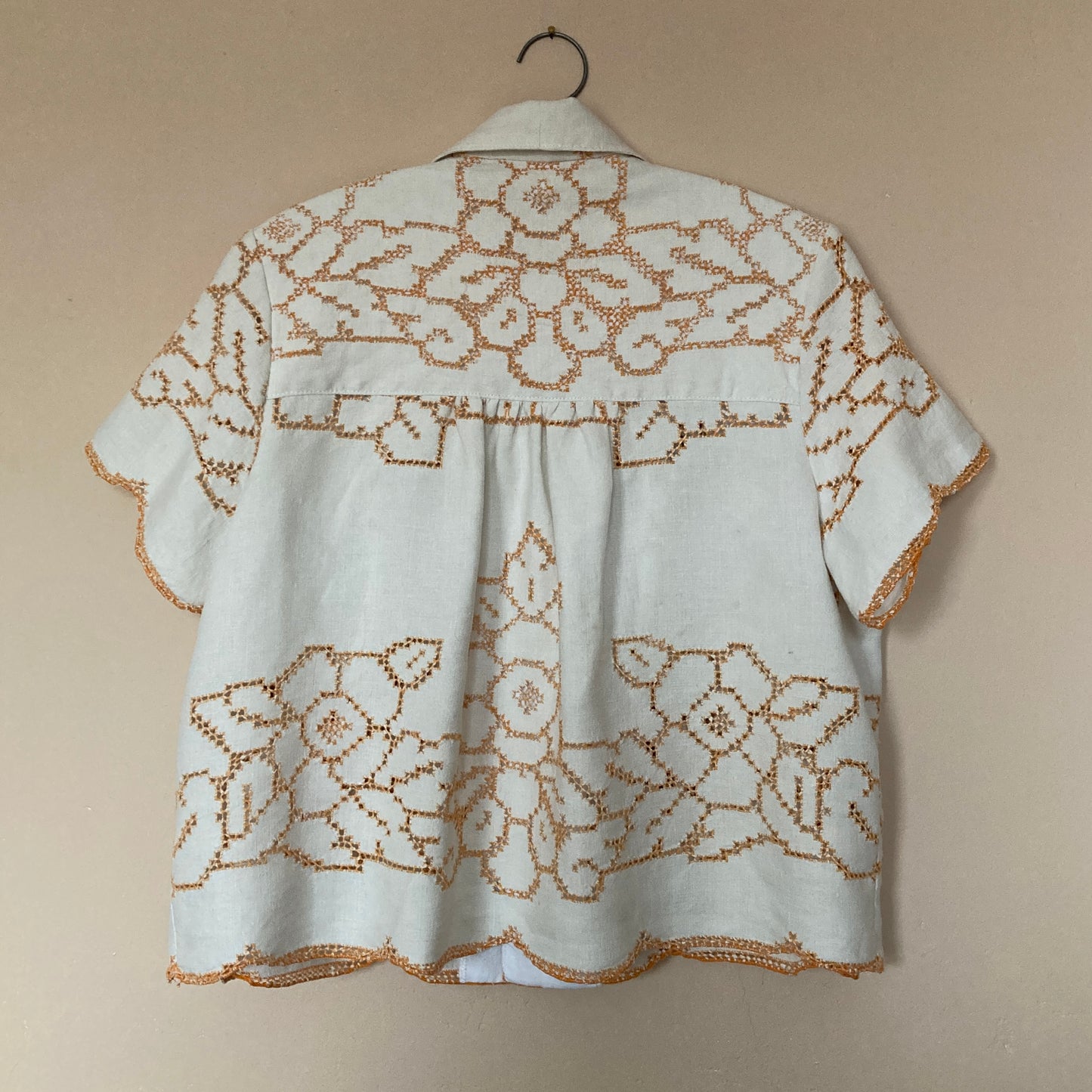 Short-sleeved shirt made from a recycled off-white linen tablecloth with orange cutwork pattern (back view)