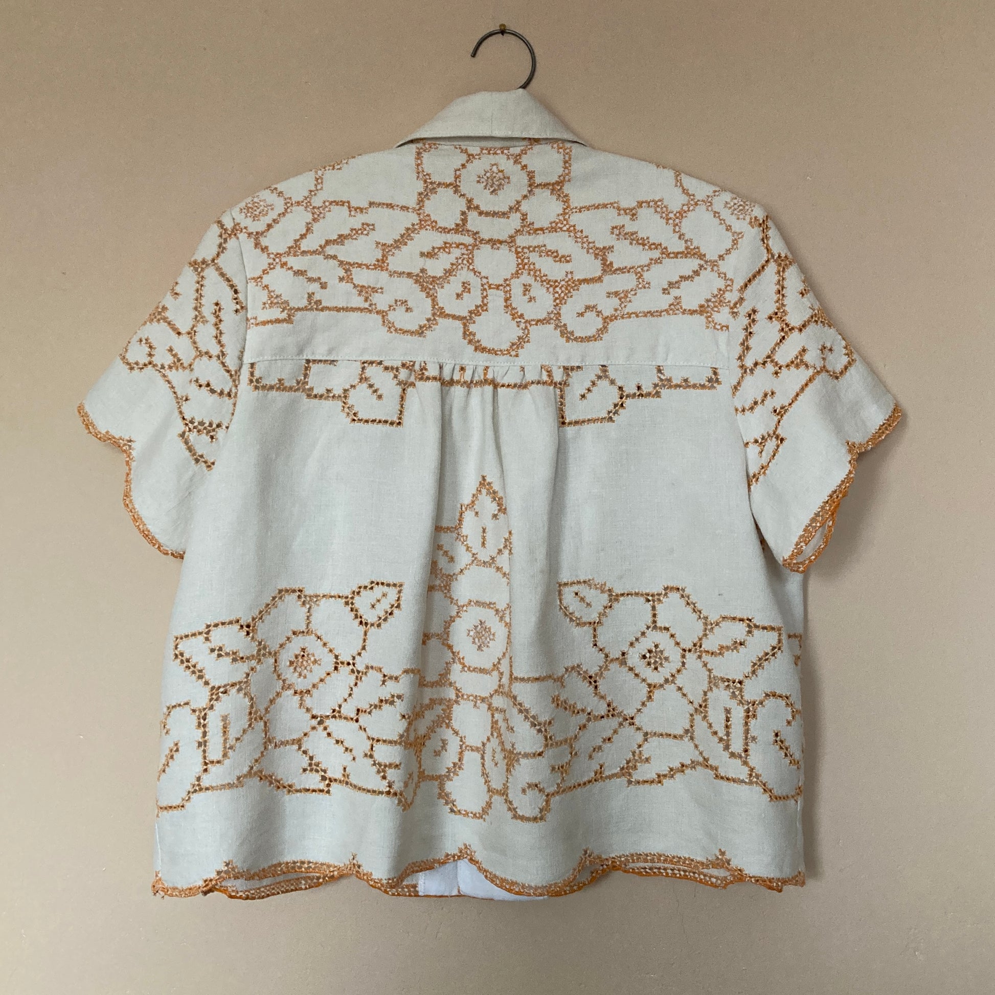 Short-sleeved shirt made from a recycled off-white linen tablecloth with orange cutwork pattern (back view)
