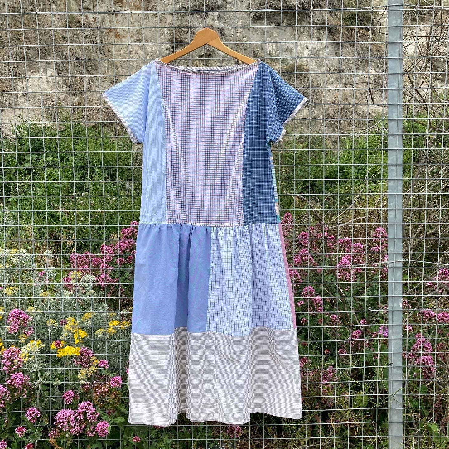 Handmade patchwork dress made from recycled cotton shirts using a vintage 1980s pattern. Boat neck. Pocket on bodice. Drop waist. Image shows the back