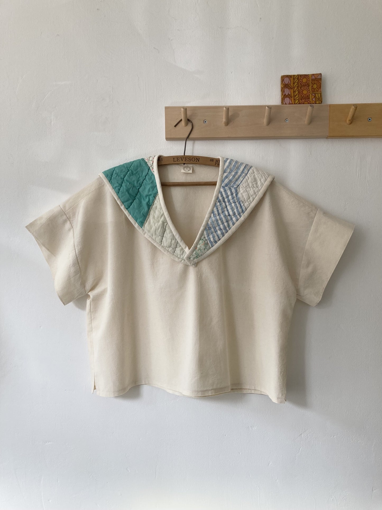 Boxy short-sleeved top made from found calico with a sailor collar cut from an antique patchwork quilt