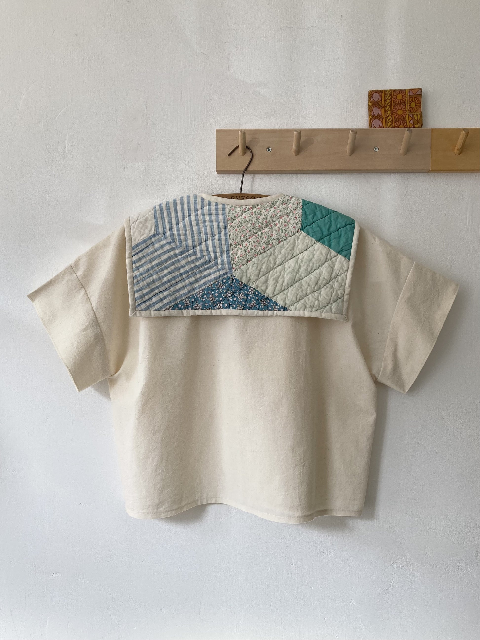 Boxy short-sleeved top made from found calico with a sailor collar cut from an antique patchwork quilt, image shows the back