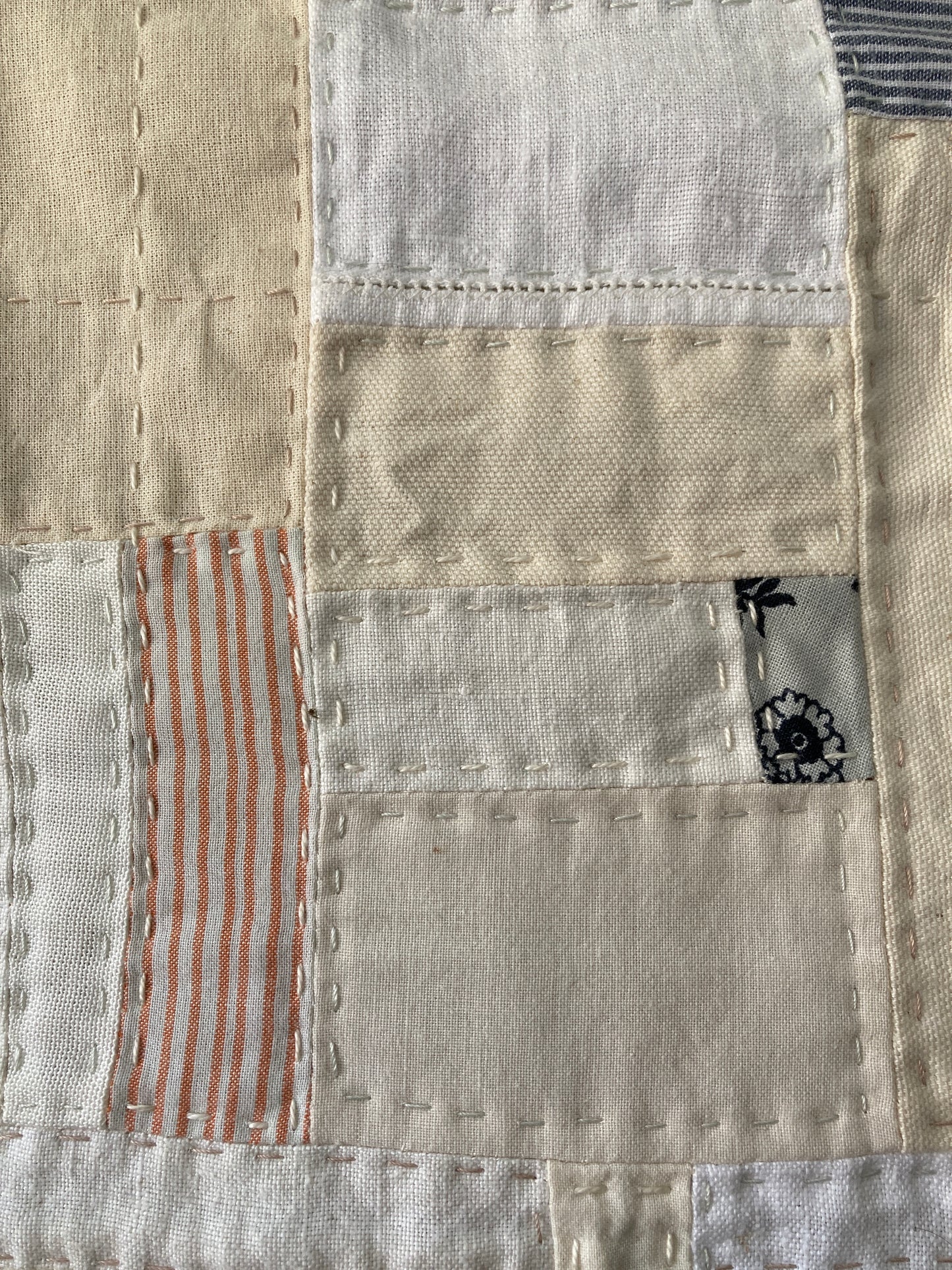 Wallhanging made from precious neutral and pastel-coloured scraps patchworked together and quilted in an improv fashion (detail)