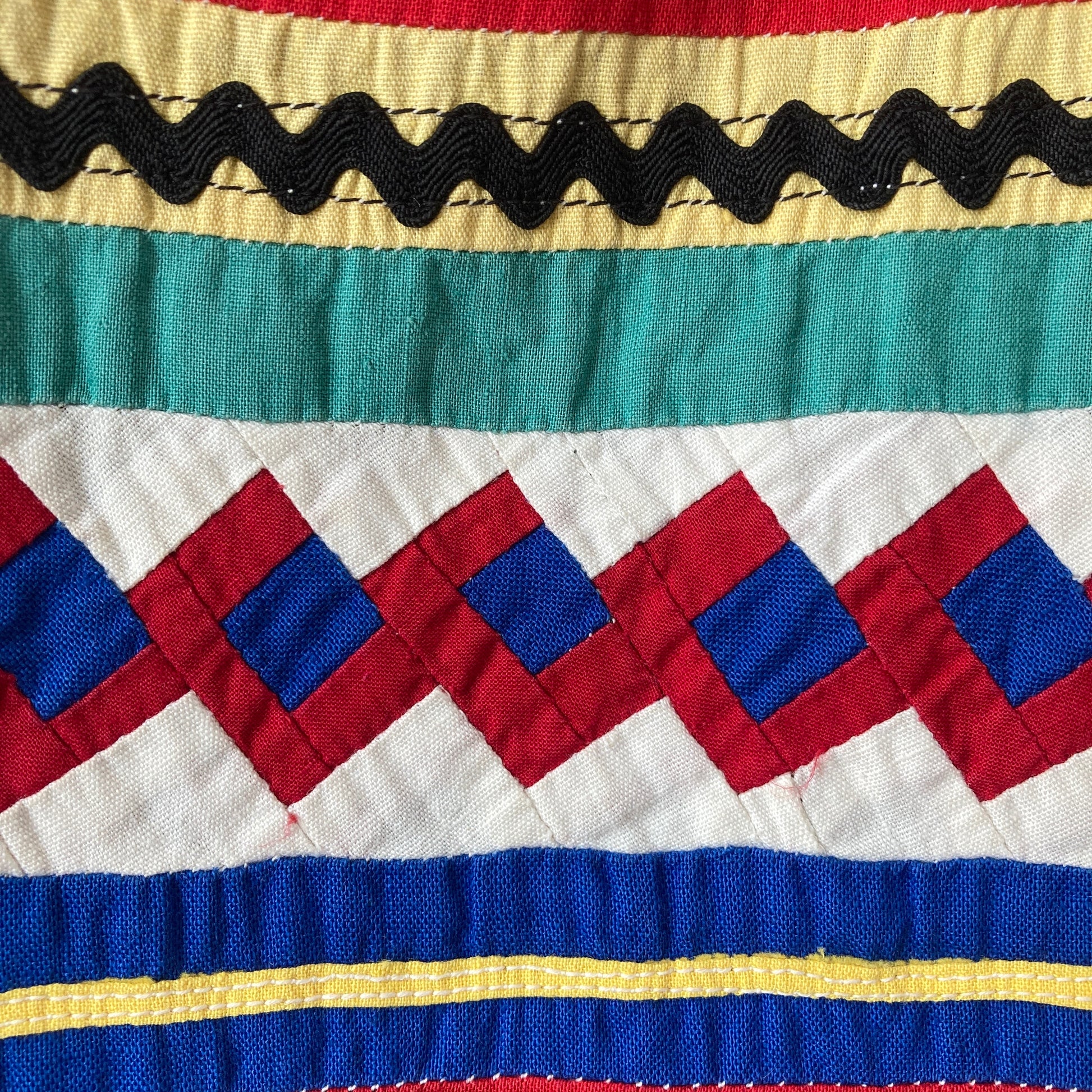 A short-sleeved shirt made from brightly coloured seminole patchwork (close-up)