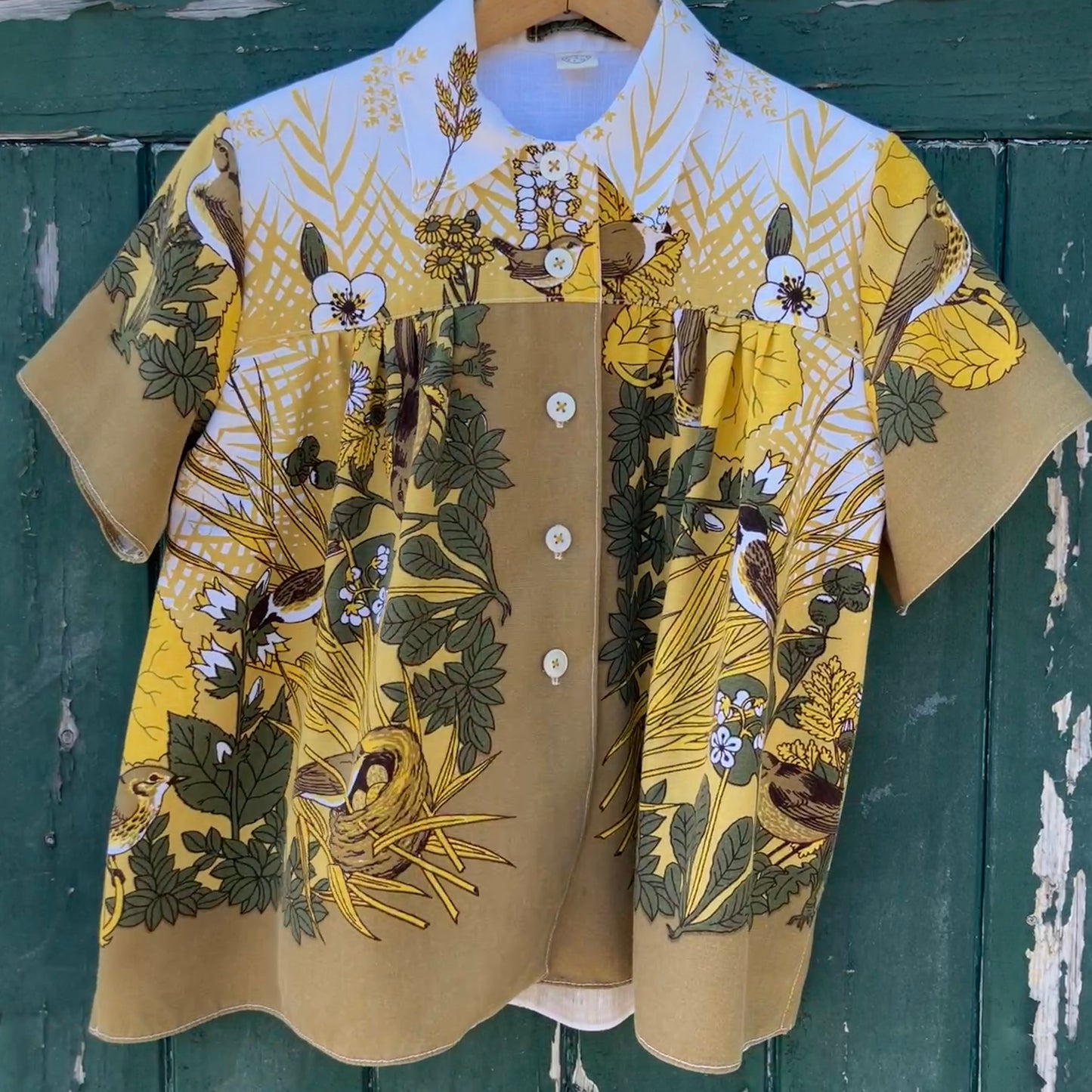 Shirt made from a recycled vintage 70s tablecloth featuring birds, birds nests, leaves, flowers and sheaves of wheat.