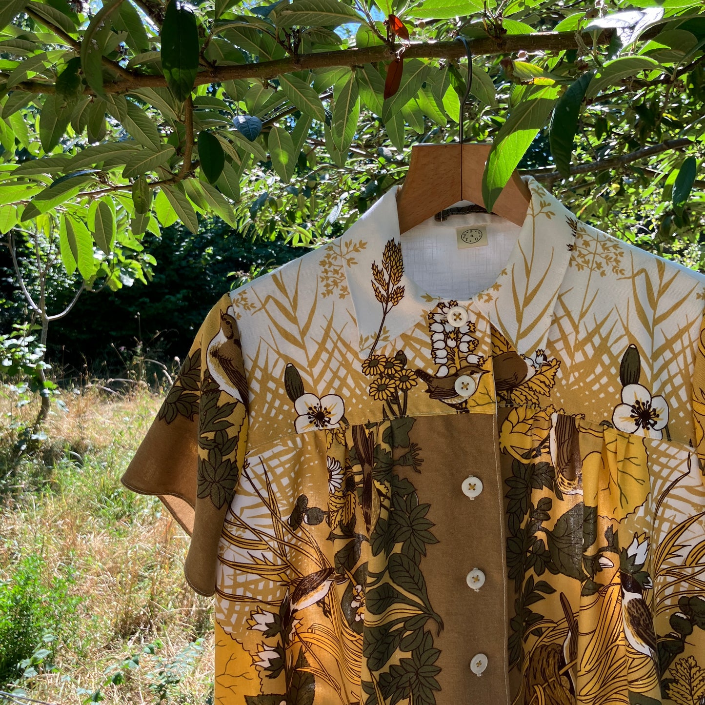 Shirt made from a recycled vintage 70s tablecloth featuring birds, birds nests, leaves, flowers and sheaves of wheat.