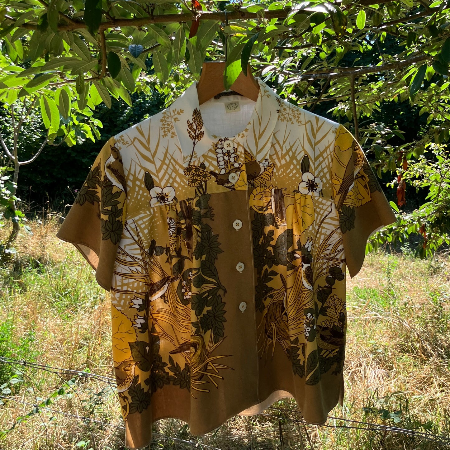 Shirt made from a recycled vintage 70s tablecloth featuring birds, birds nests, leaves, flowers and sheaves of wheat.