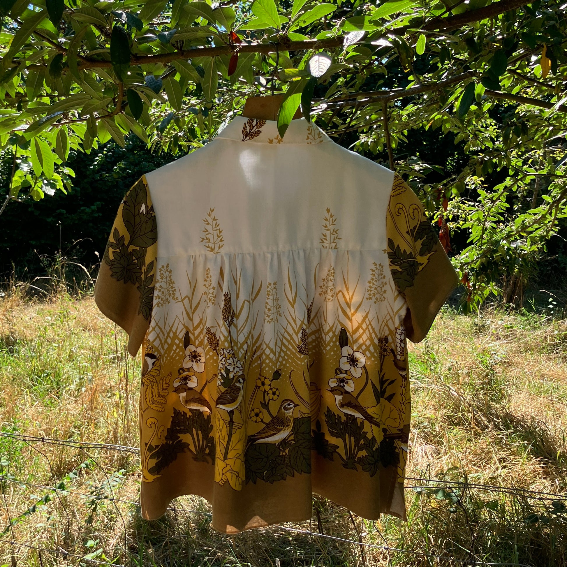 Shirt made from a recycled vintage 70s tablecloth featuring birds, birds nests, leaves, flowers and sheaves of wheat.