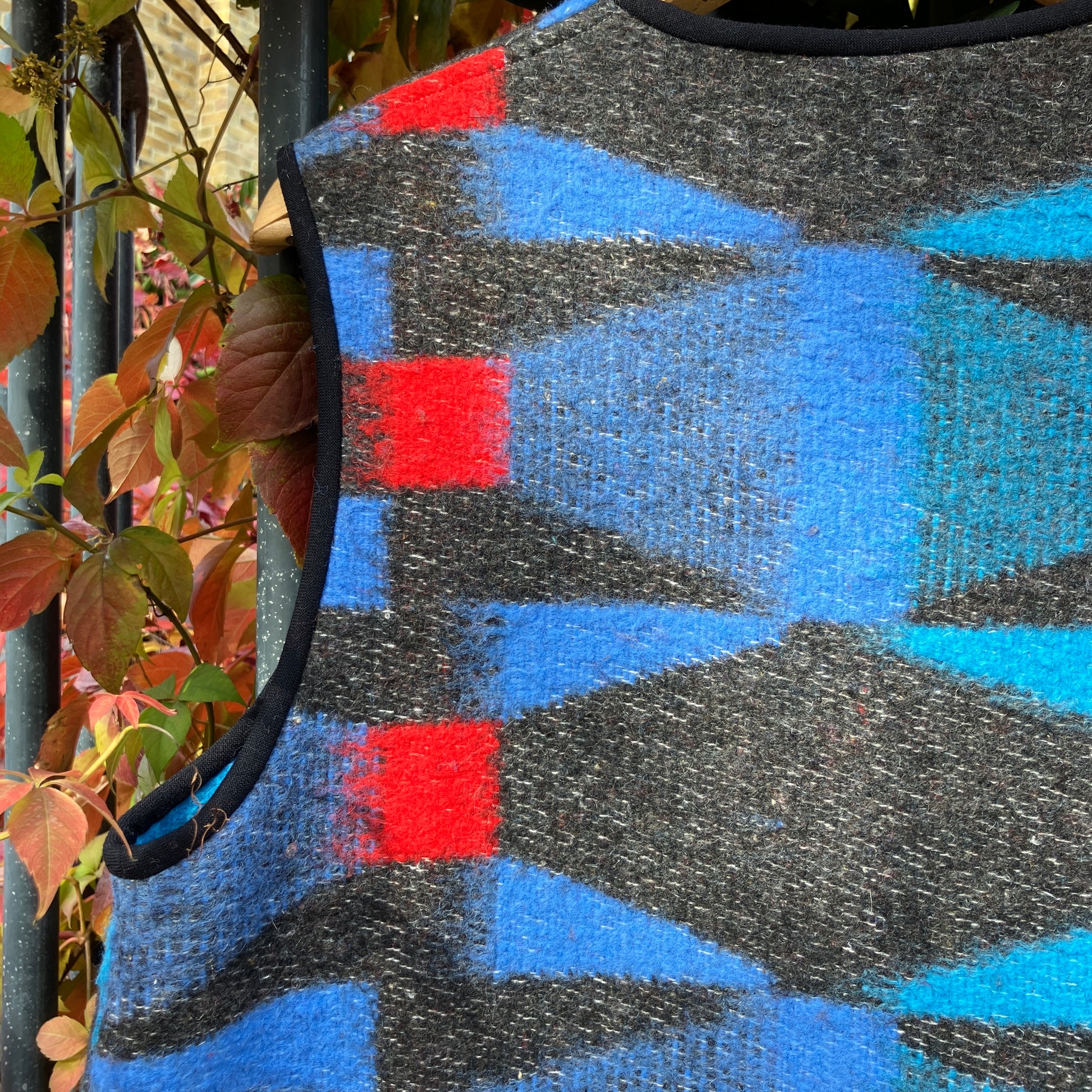 Cosy vest made from a striking geometric vintage blanket in shades of blue and red.