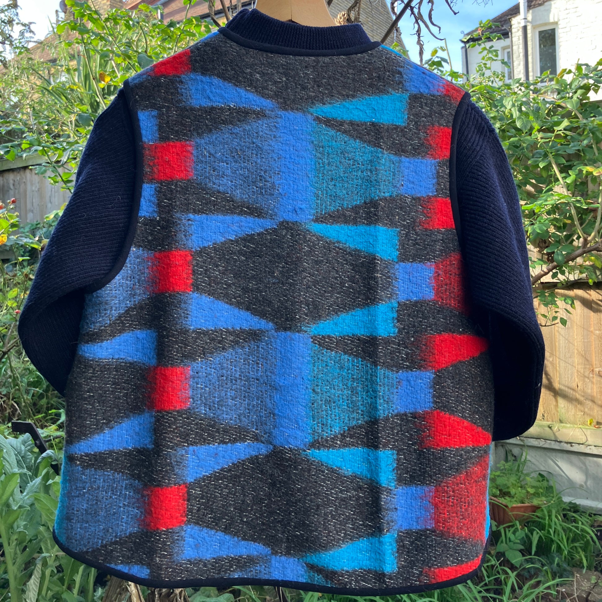 Cosy vest made from a striking geometric vintage blanket in shades of blue and red.