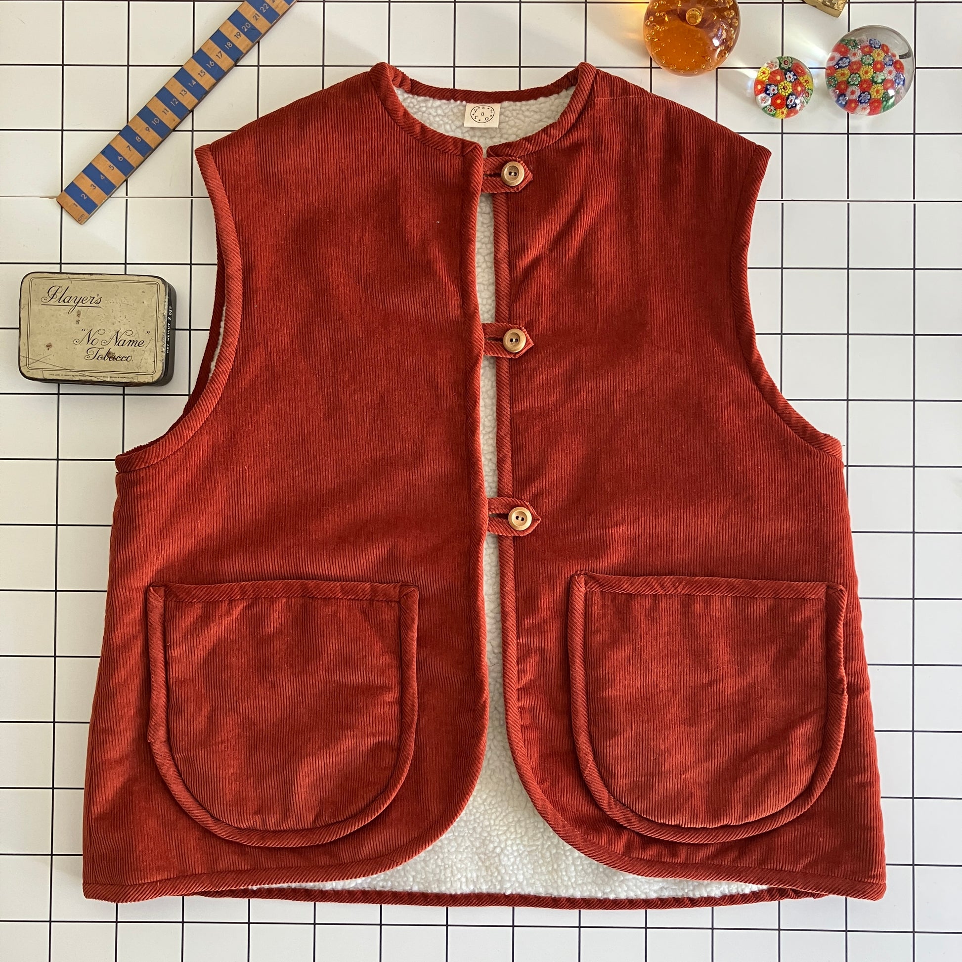 Cosy vest/waistcoat made from a secondhand remnant of rust-coloured corduroy, lined with found faux sheepskin fleece