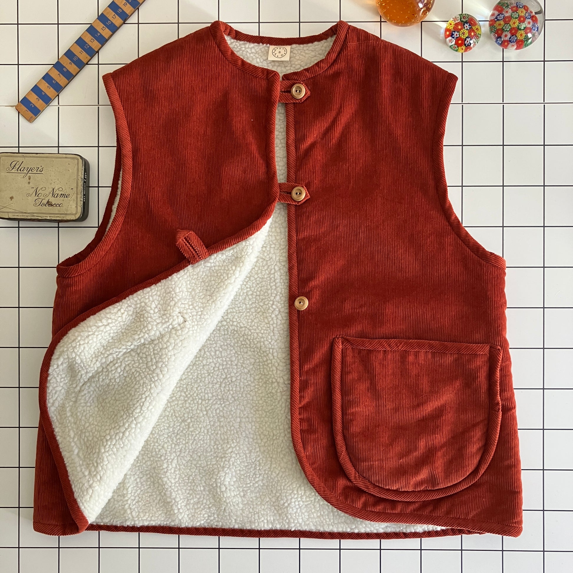 Cosy vest/waistcoat made from a secondhand remnant of rust-coloured corduroy, lined with found faux sheepskin fleece