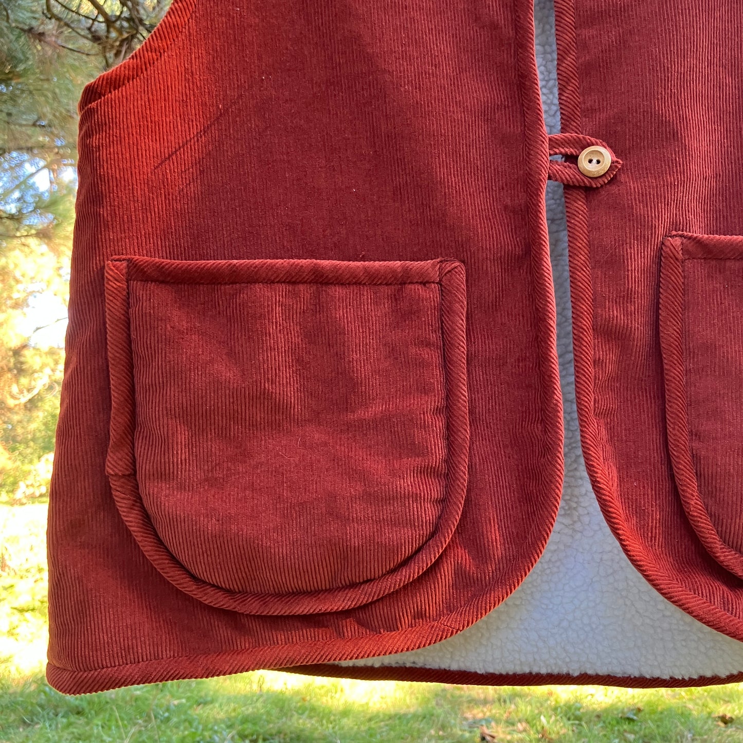 Cosy vest/waistcoat made from a secondhand remnant of rust-coloured corduroy, lined with found faux sheepskin fleece