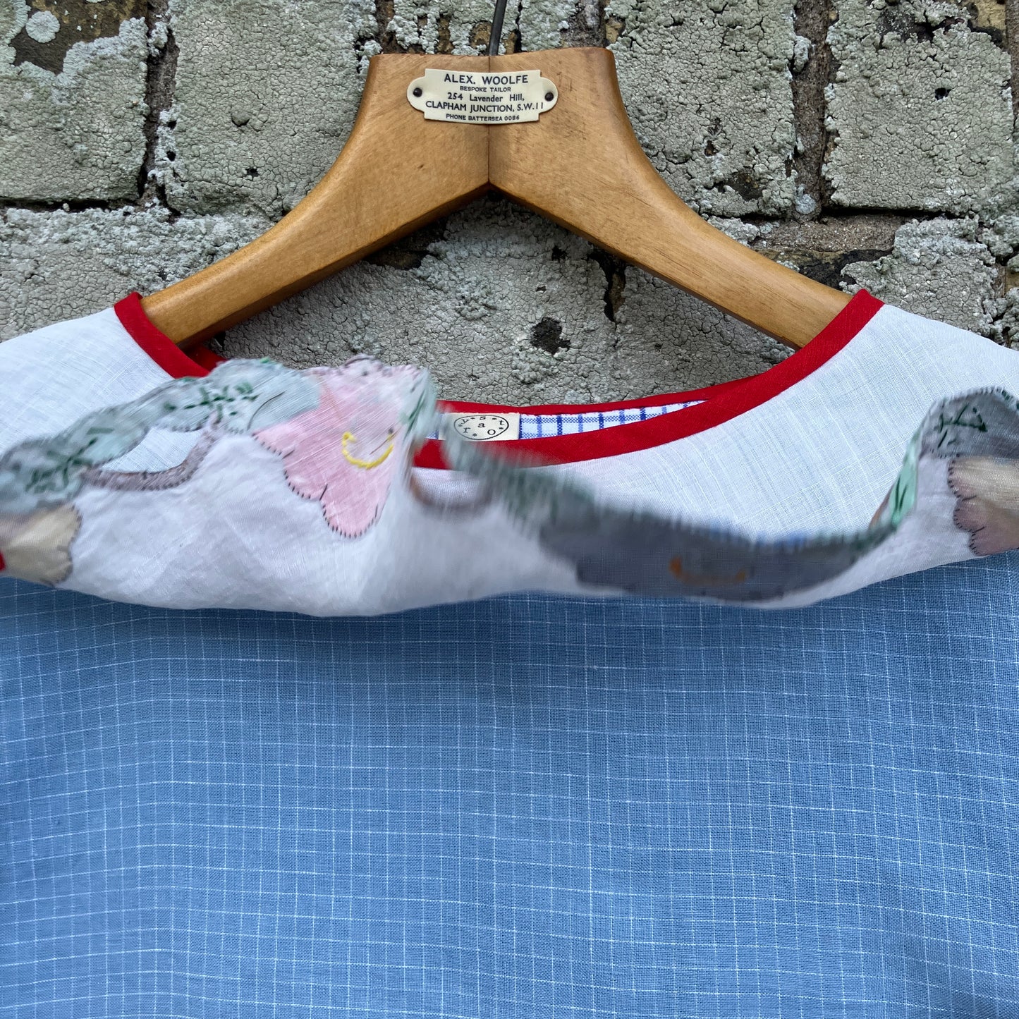 Short-sleeved top made from found offcuts of checked linen and a round floral table mat forming the collar.