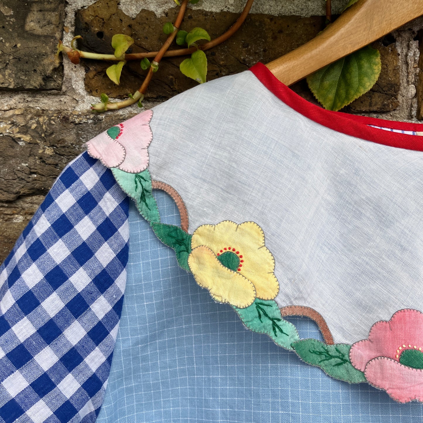 Short-sleeved top made from found offcuts of checked linen and a round floral table mat forming the collar.