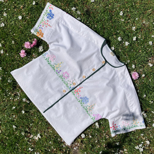 boxy top with embroidered flowers across the front and round the sleeves - and a country cottage on the back