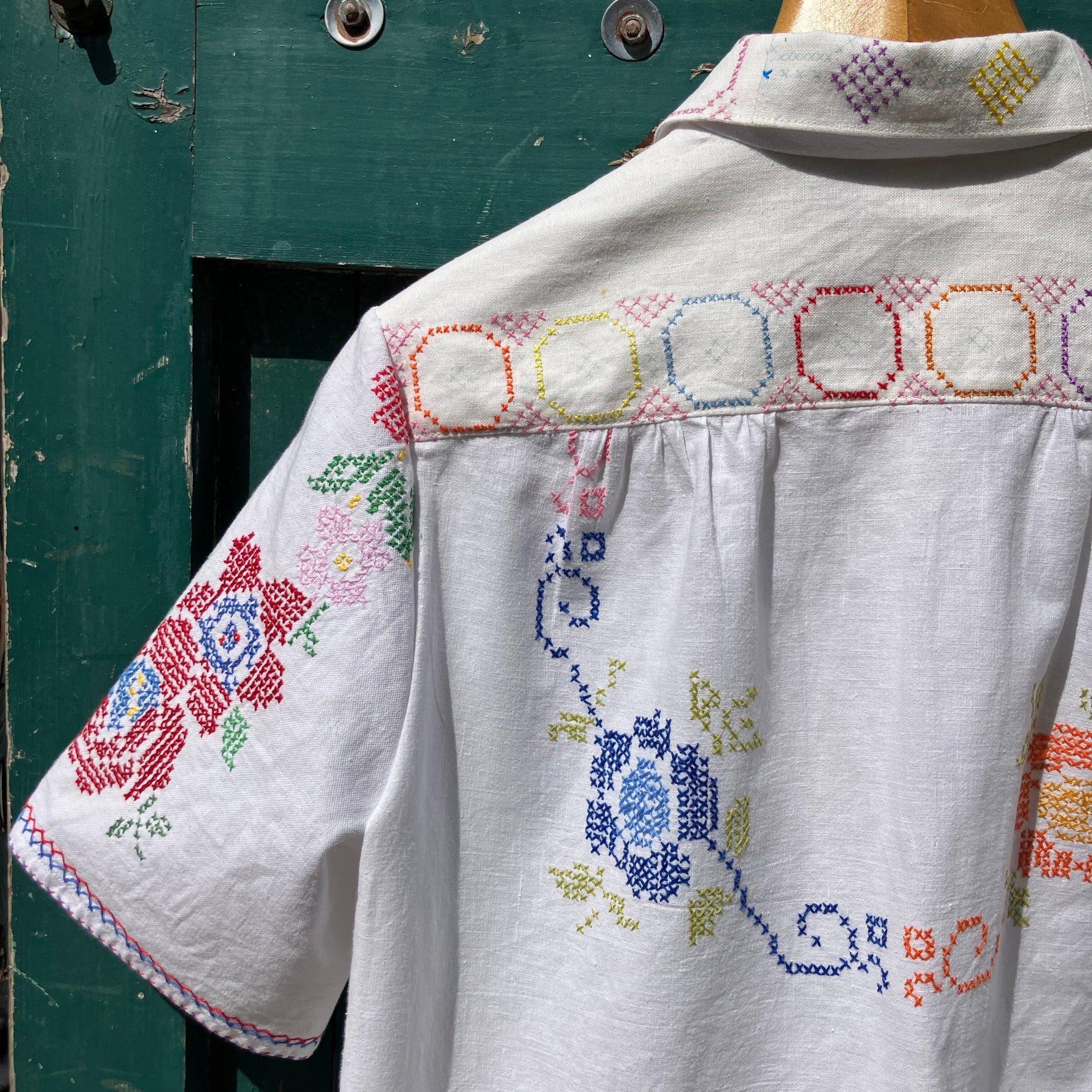 Shirt made from a selection of recycled vintage cotton tablecloths with floral and geometric cross stitch patterns
