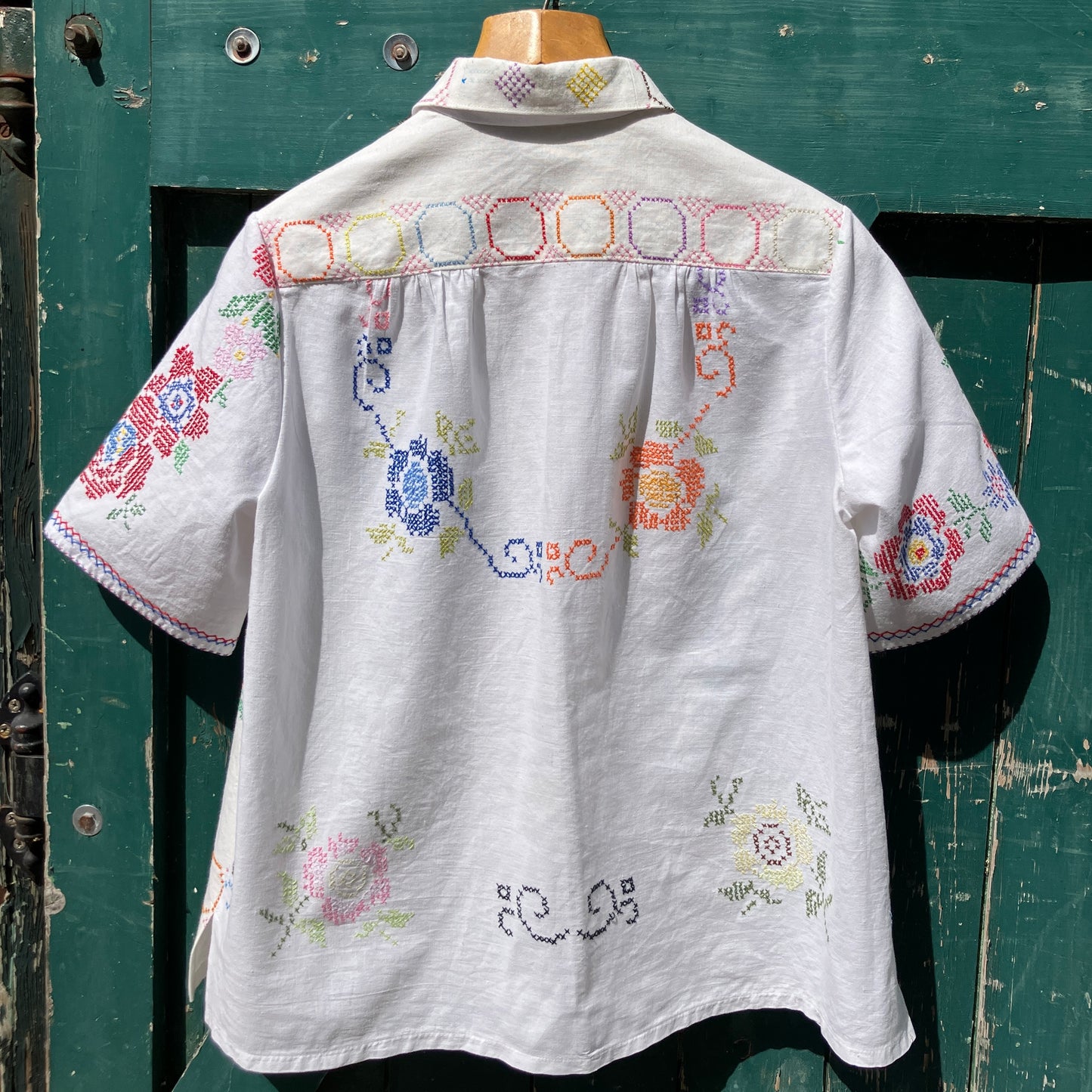 Shirt made from a selection of recycled vintage cotton tablecloths with floral and geometric cross stitch patterns