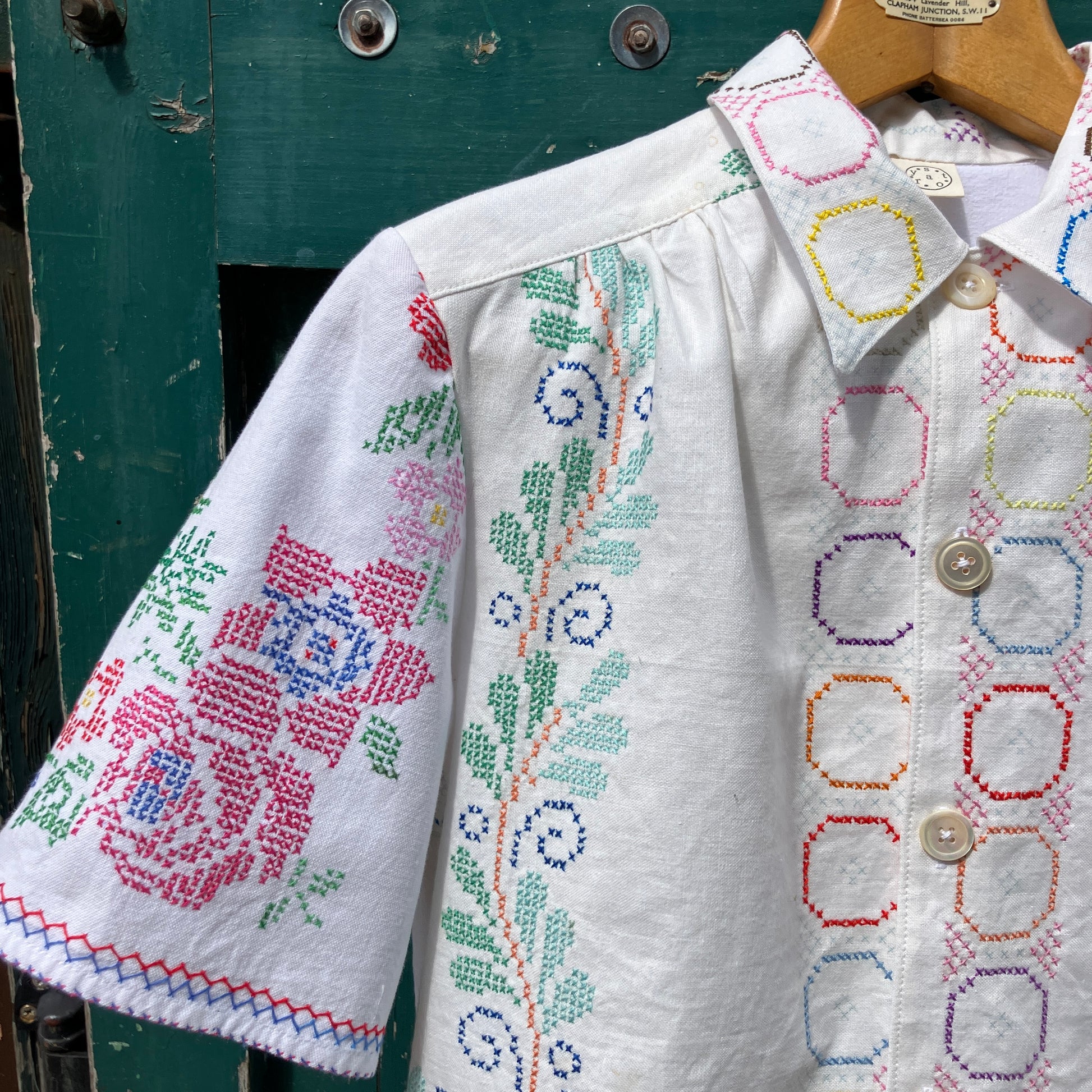 Shirt made from a selection of vintage cotton tablecloths with floral and geometric cross stitch patterns