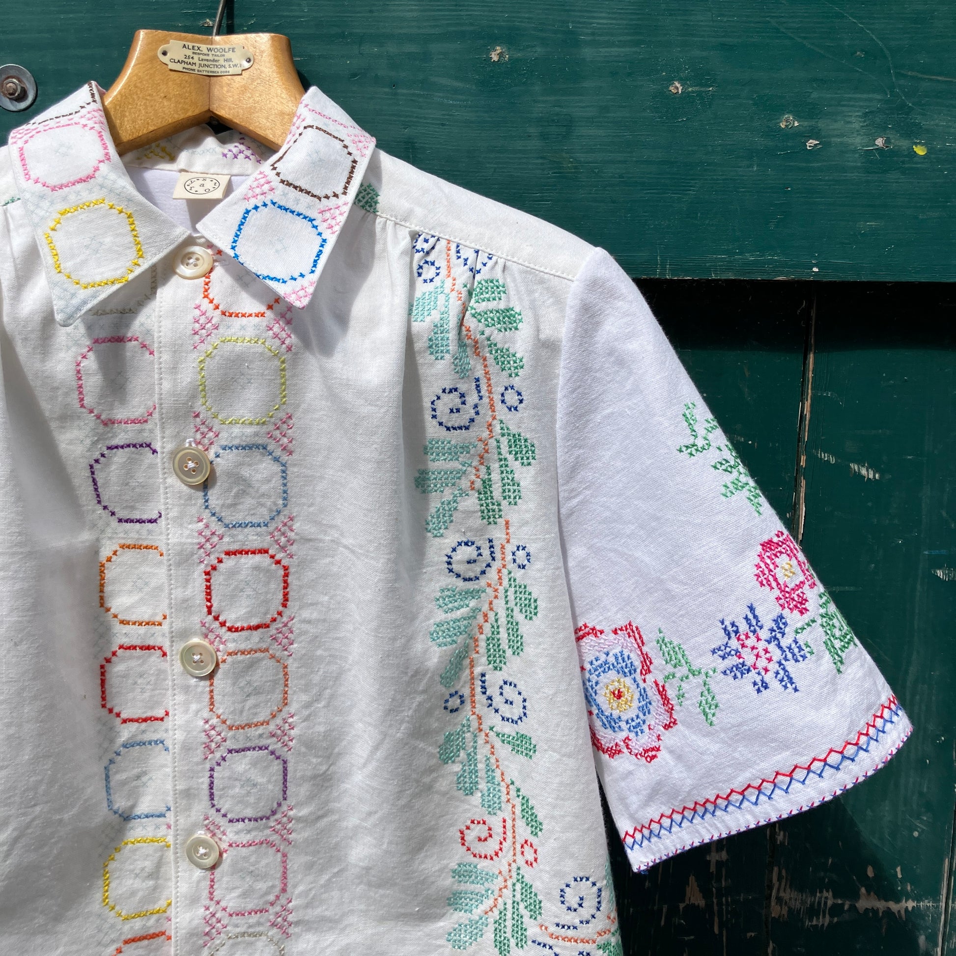 Shirt made from a selection of recycled vintage cotton tablecloths with floral and geometric cross stitch patterns