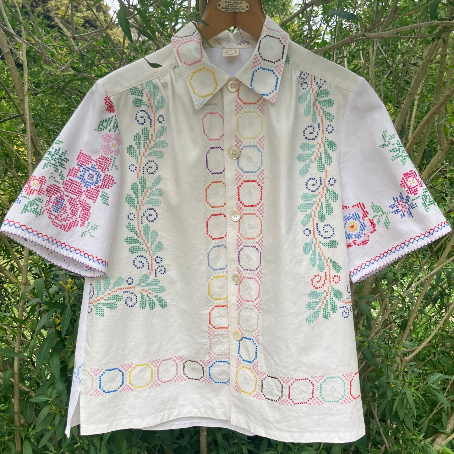 Shirt made from a selection of recycled vintage cotton tablecloths with floral and geometric cross stitch patterns