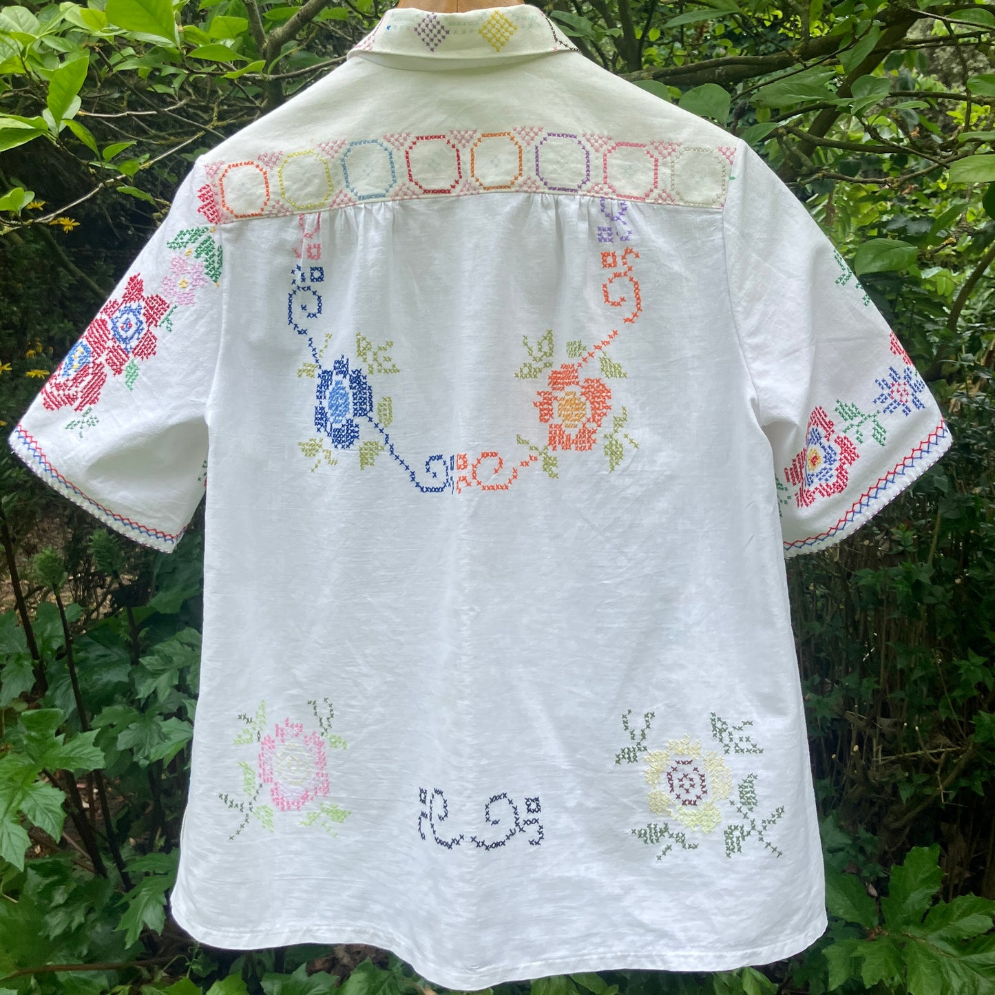Shirt made from a selection of recycled vintage cotton tablecloths with floral and geometric cross stitch patterns