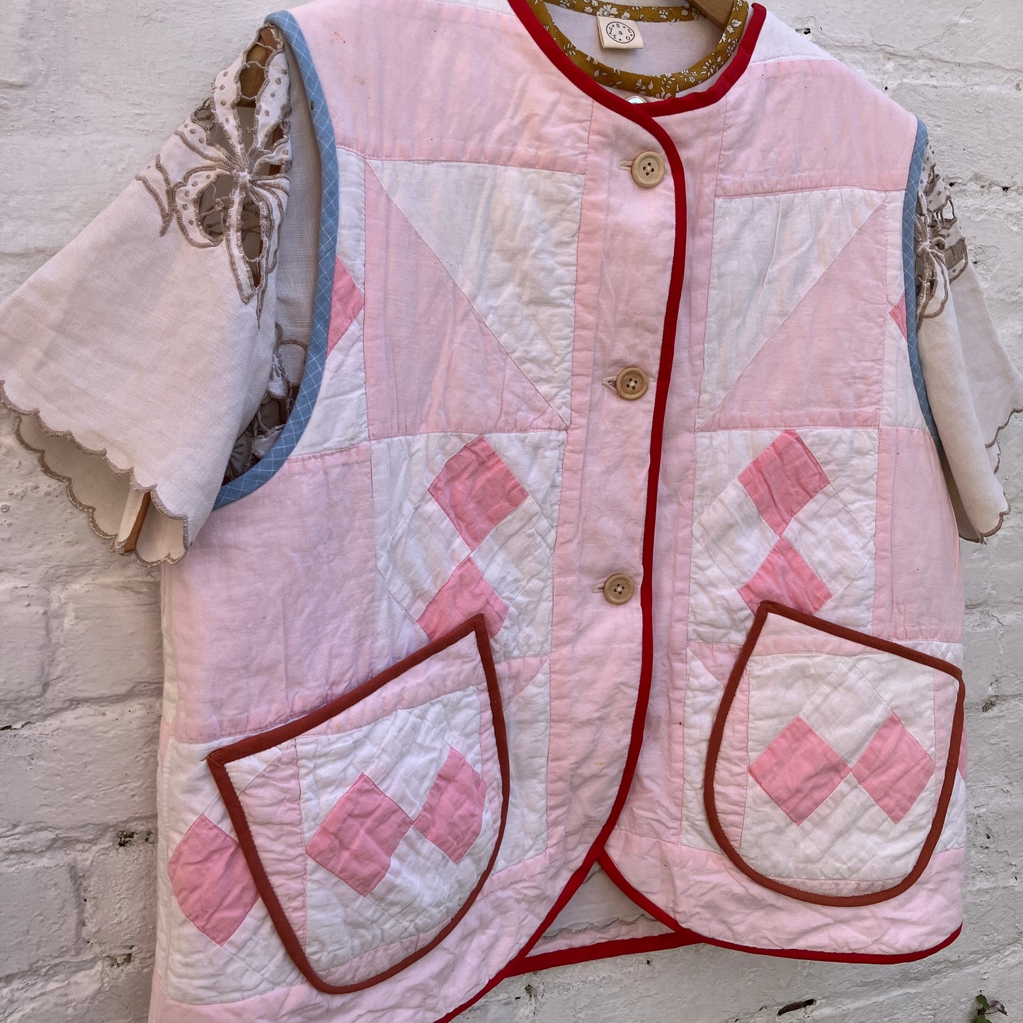 Top made from a vintage cutwork linen tablecloth under a pink patchwork vest