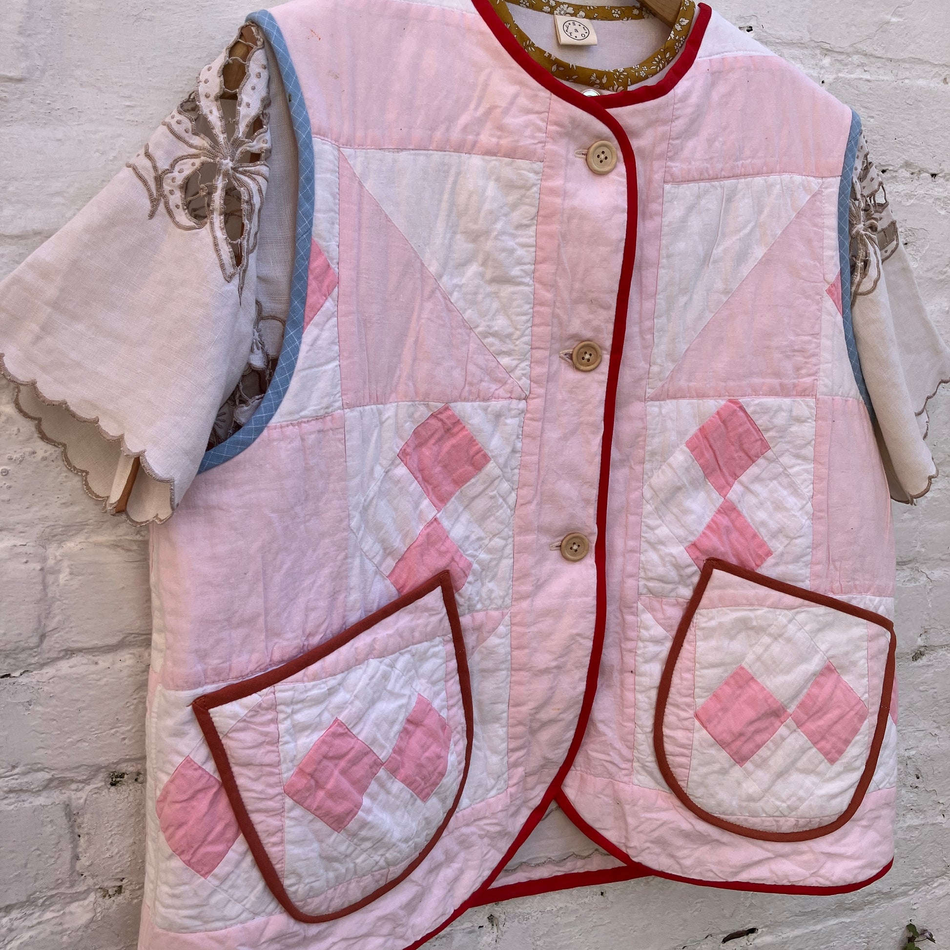 Top made from a vintage cutwork linen tablecloth under a pink patchwork vest