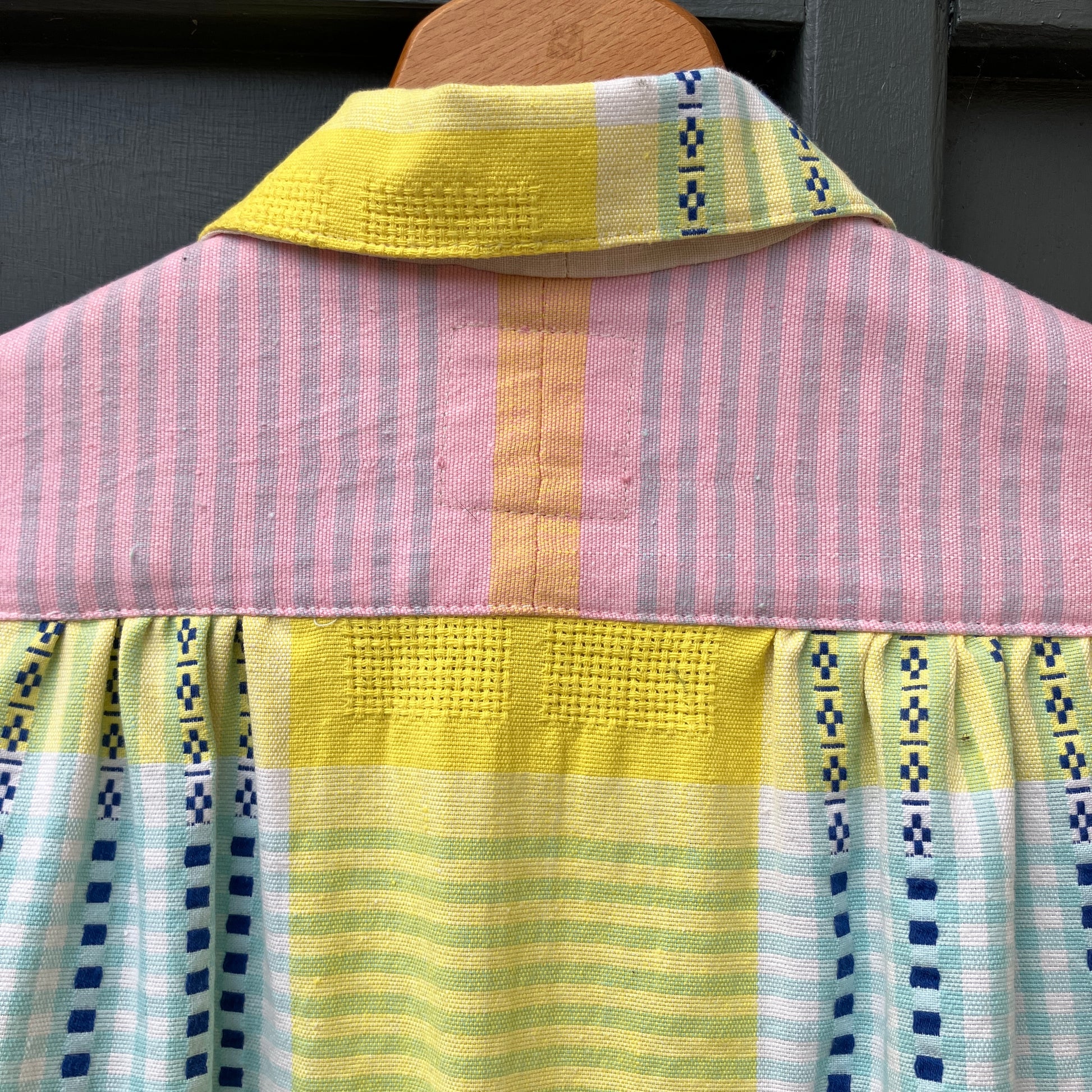 Shirt made from a reclaimed cotton tablecloth in shades of pink, blue, peach and bright yellow