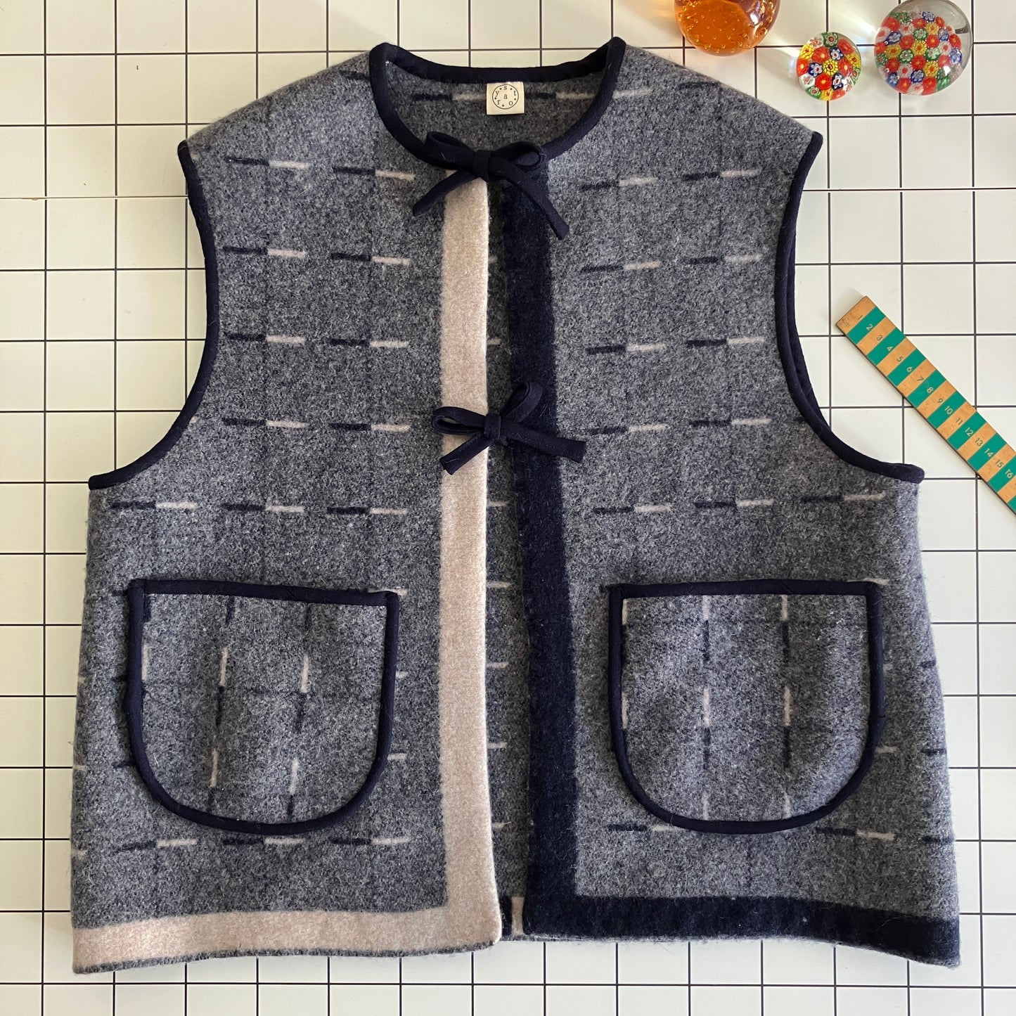 Cosy vest made from a reclaimed grey and blue lambswool blanket with two tie fastenings