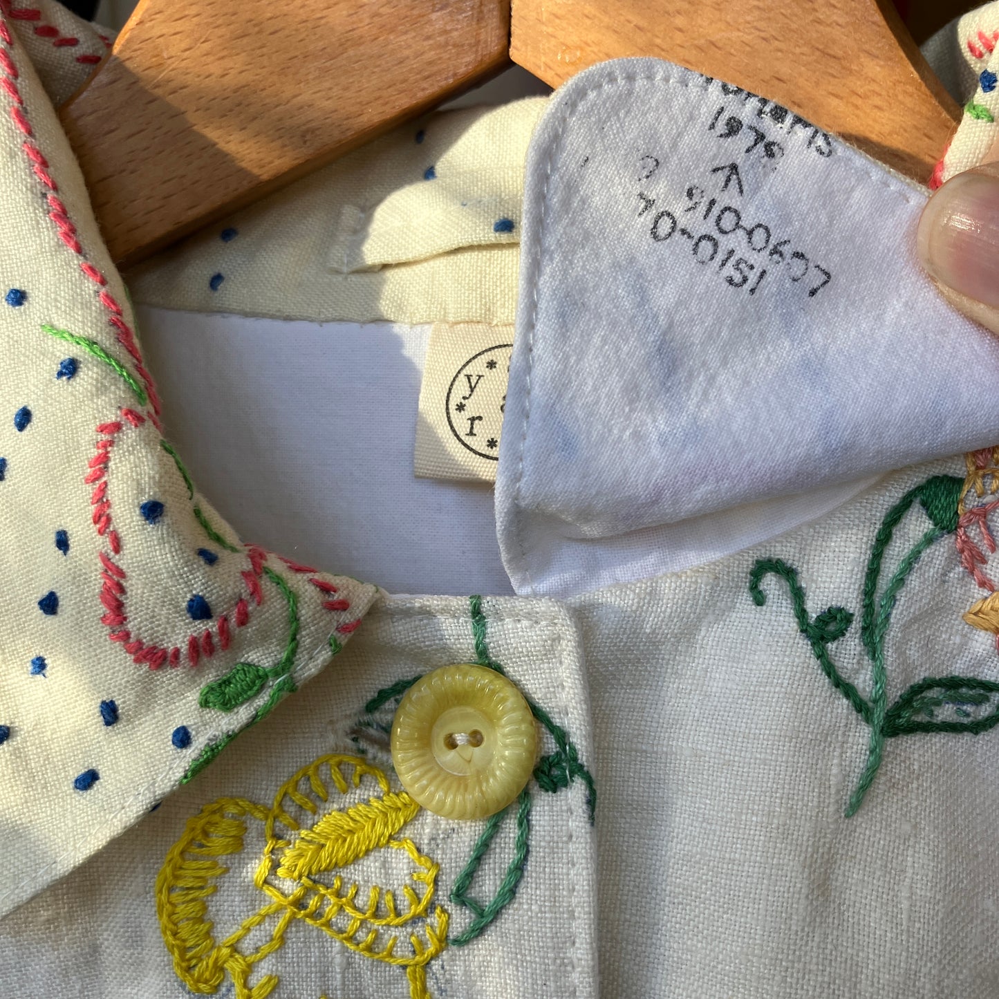 Close-up of recycled tablecloth blouse with a button and under collar detail