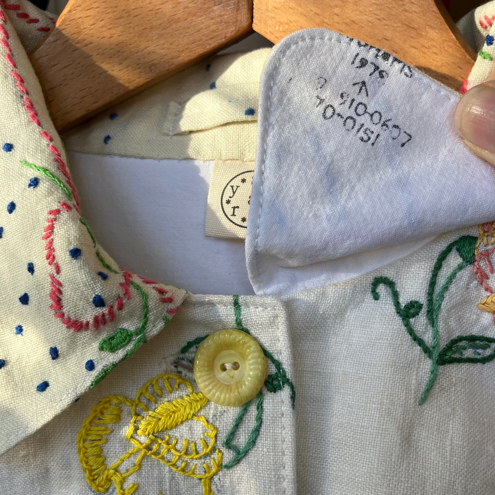 Close-up of recycled tablecloth blouse with a button and under collar detail