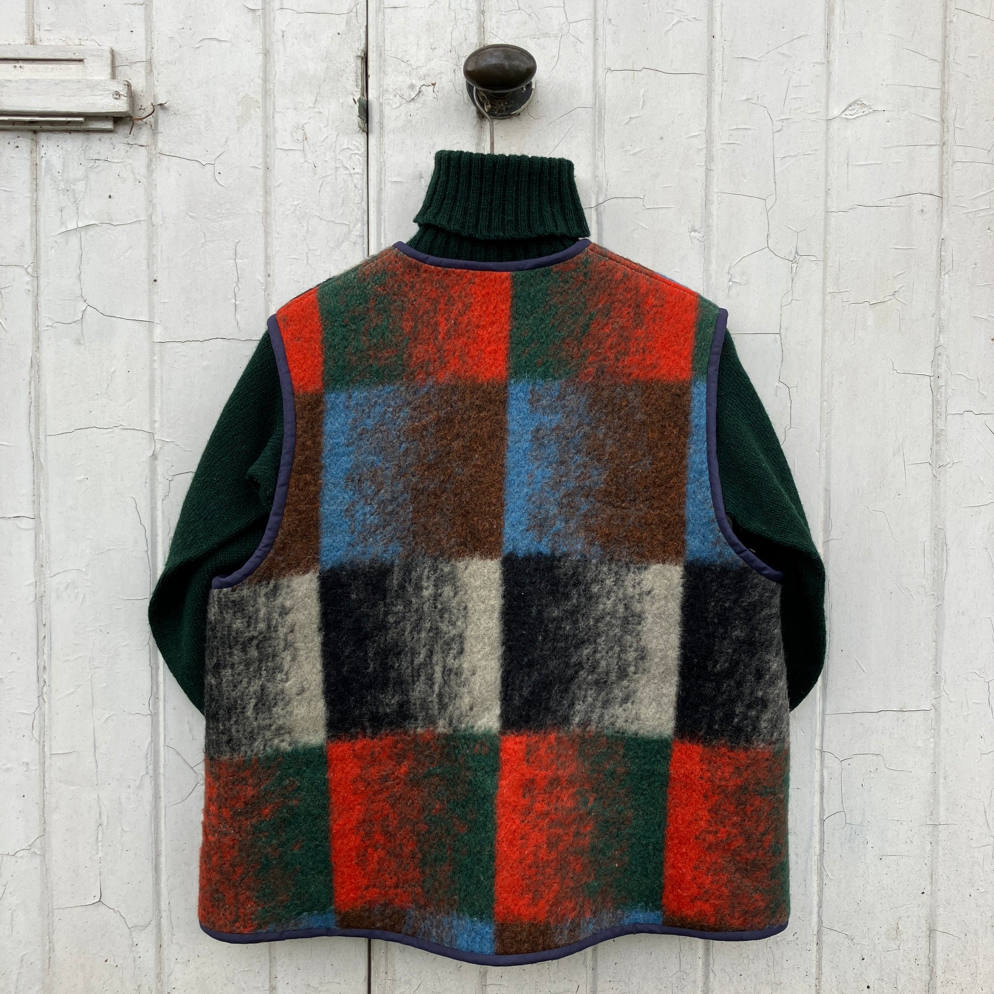 cosy vest or waistcoat made from a thick vintage wool blanket in rich hues of green, orange, blue and brown reminiscent of an oil painting