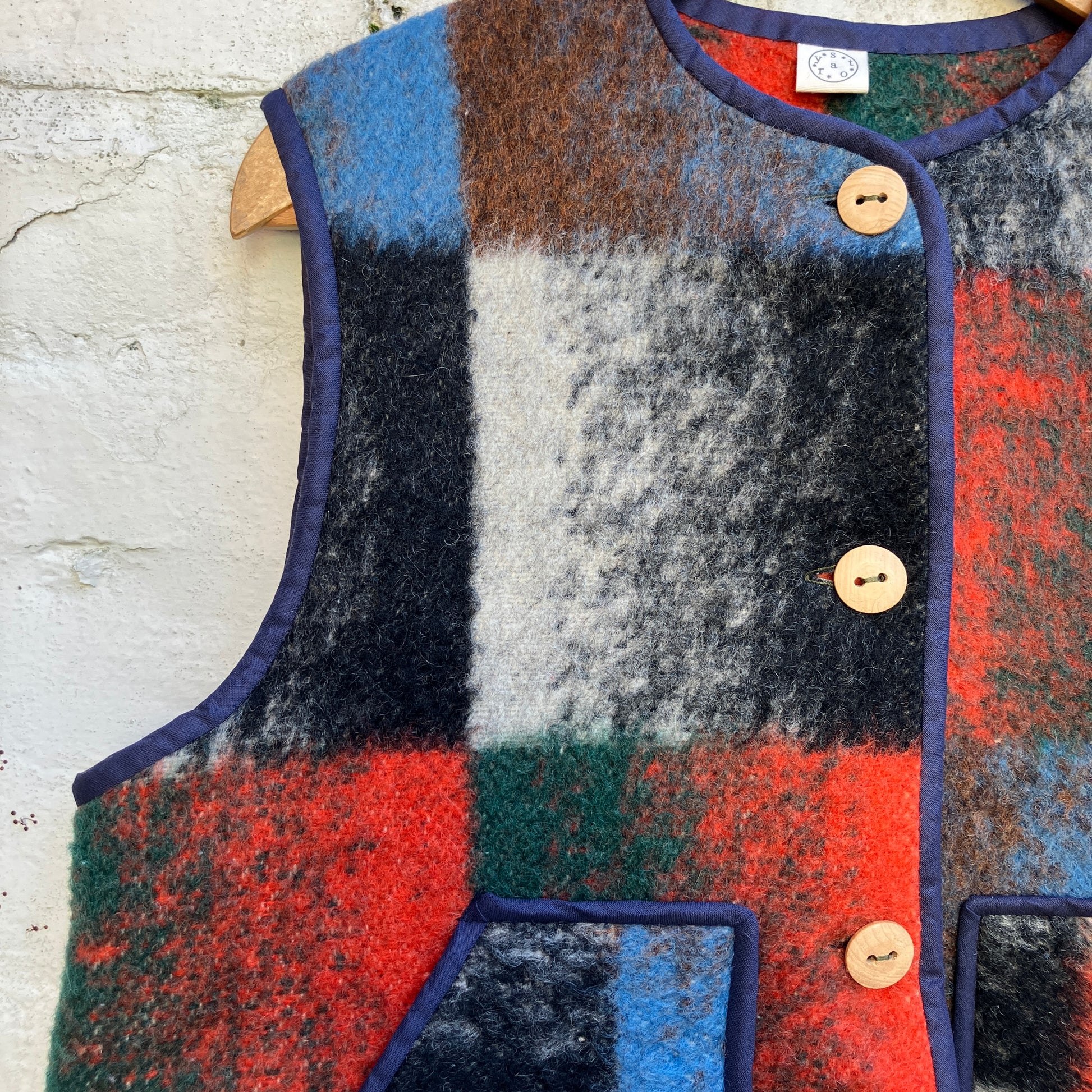 cosy vest or waistcoat made from a thick vintage wool blanket in rich hues of green, orange, blue and brown reminiscent of an oil painting