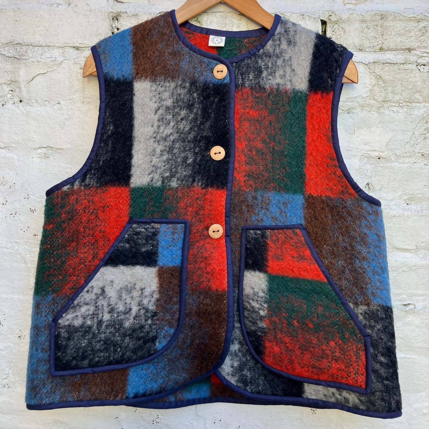 cosy vest or waistcoat made from a thick vintage wool blanket in rich hues of green, orange, blue and brown reminiscent of an oil painting