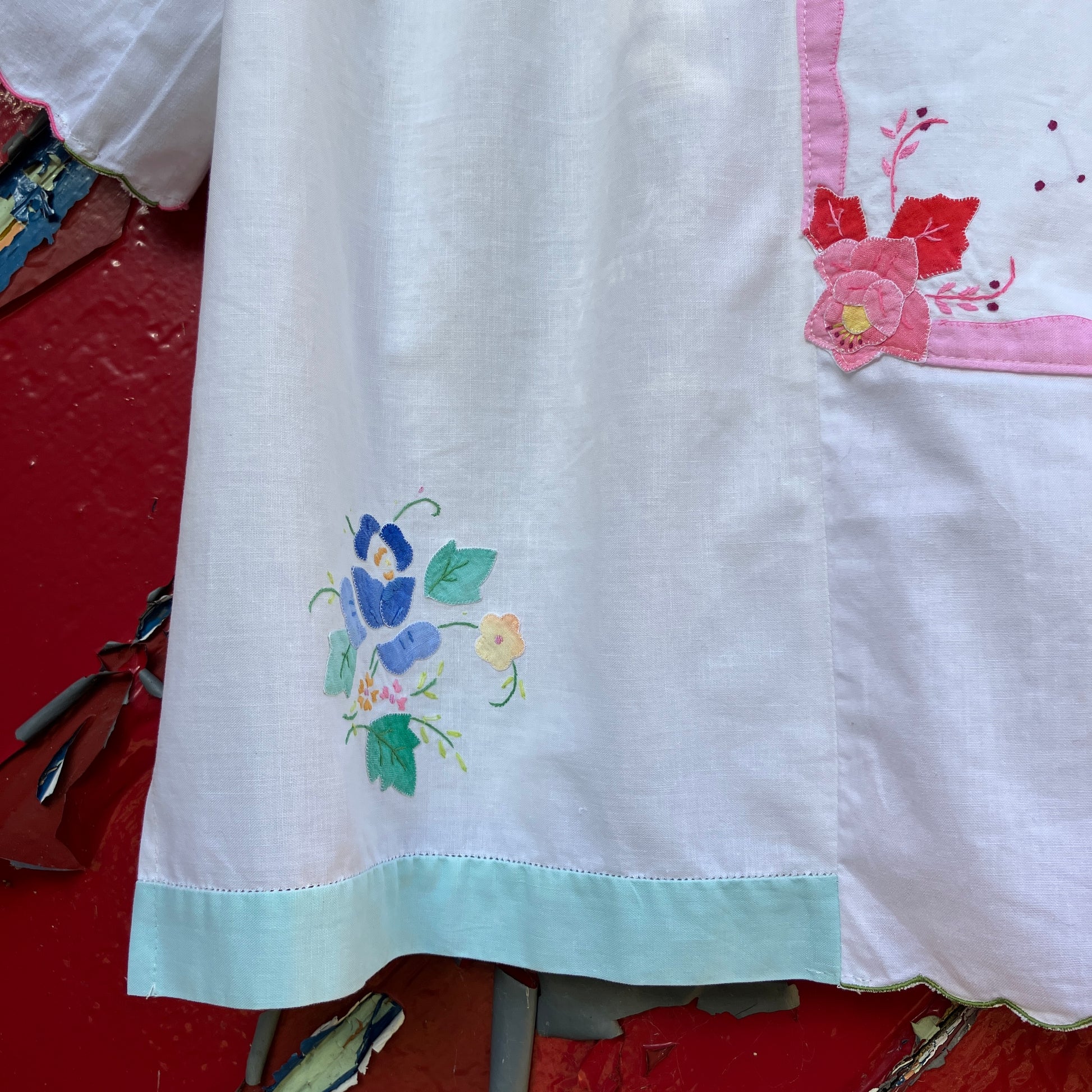 linen and cotton shirt made from a patchwork of reclaimed vintage napkins and placemats with detailed appliqué flowers and pastel borders