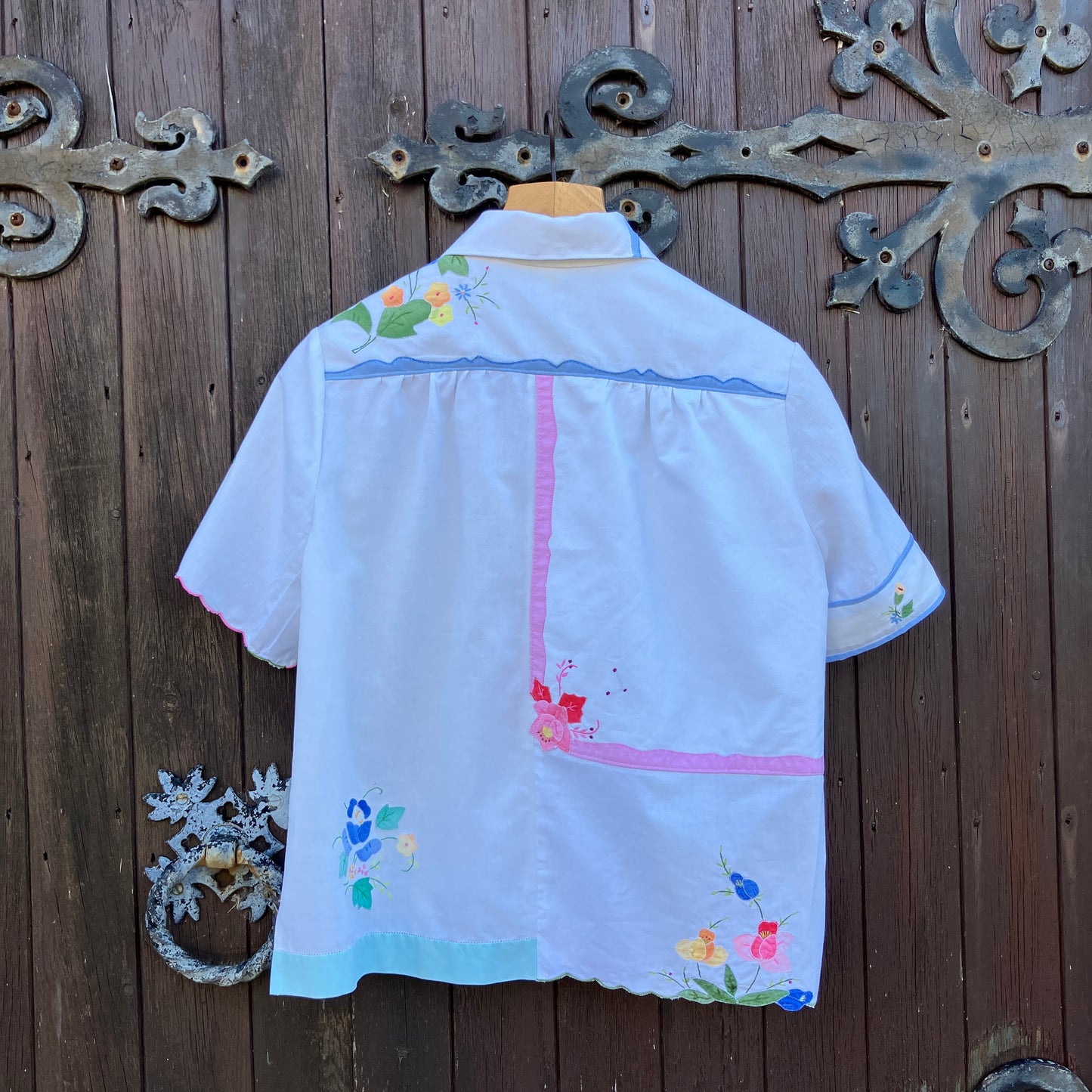 linen and cotton shirt made from a patchwork of reclaimed vintage napkins and placemats with detailed appliqué flowers and pastel borders