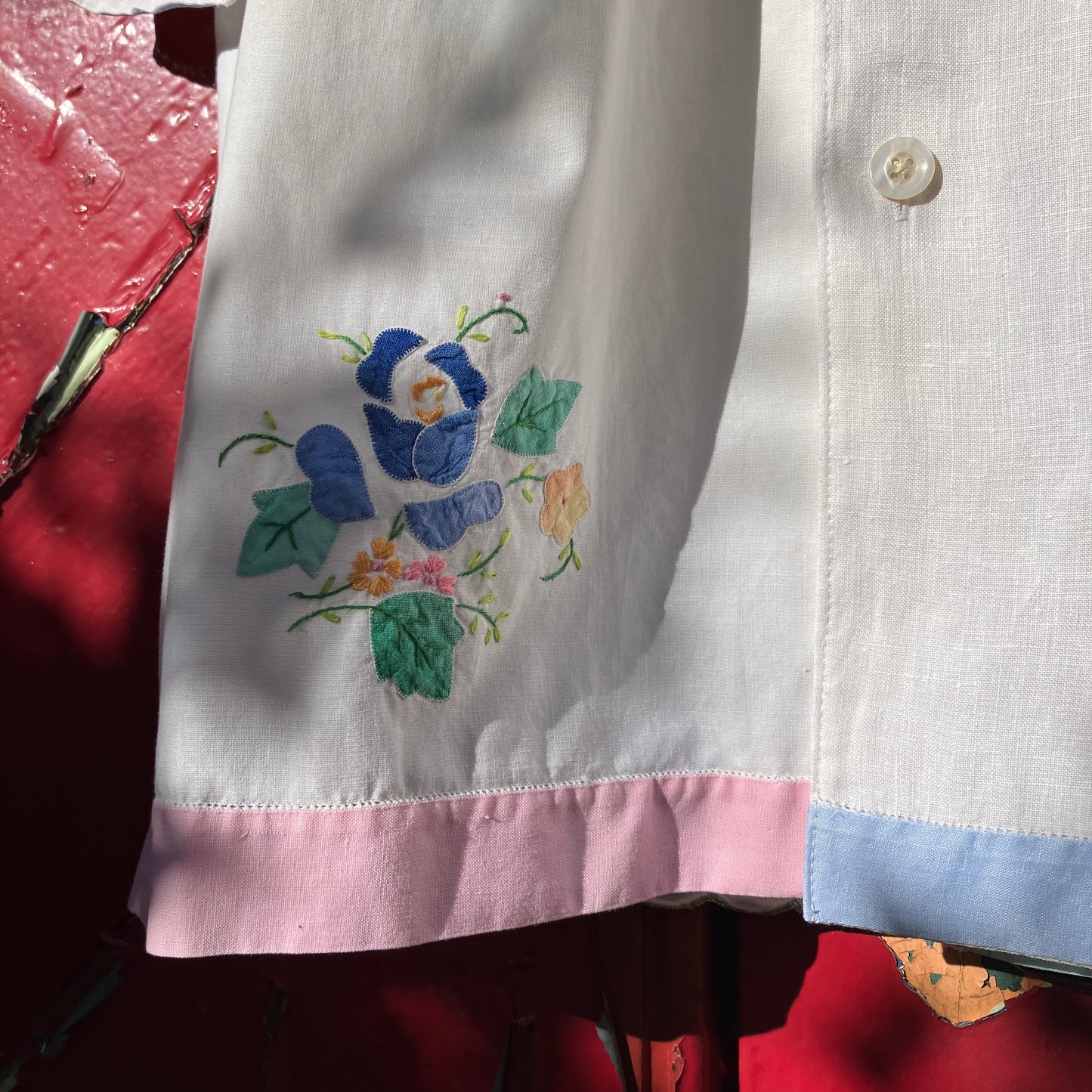 linen and cotton shirt made from a patchwork of reclaimed vintage napkins and placemats with detailed appliqué flowers and pastel borders