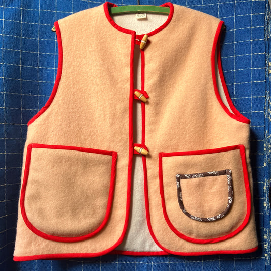 Vest/waistcoat made from a recycled vintage pink wool blanket, with red cotton binding and vintage wooden toggles