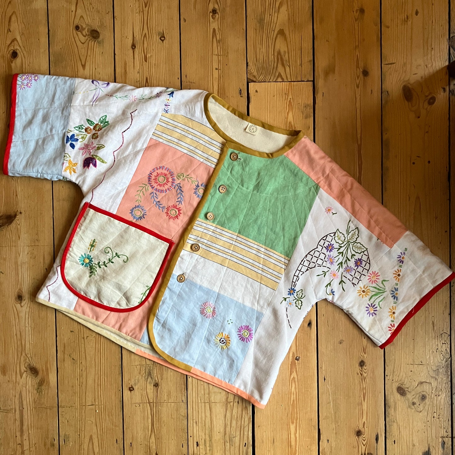 quilted top or jacket made from a patchwork of vintage tablecloths