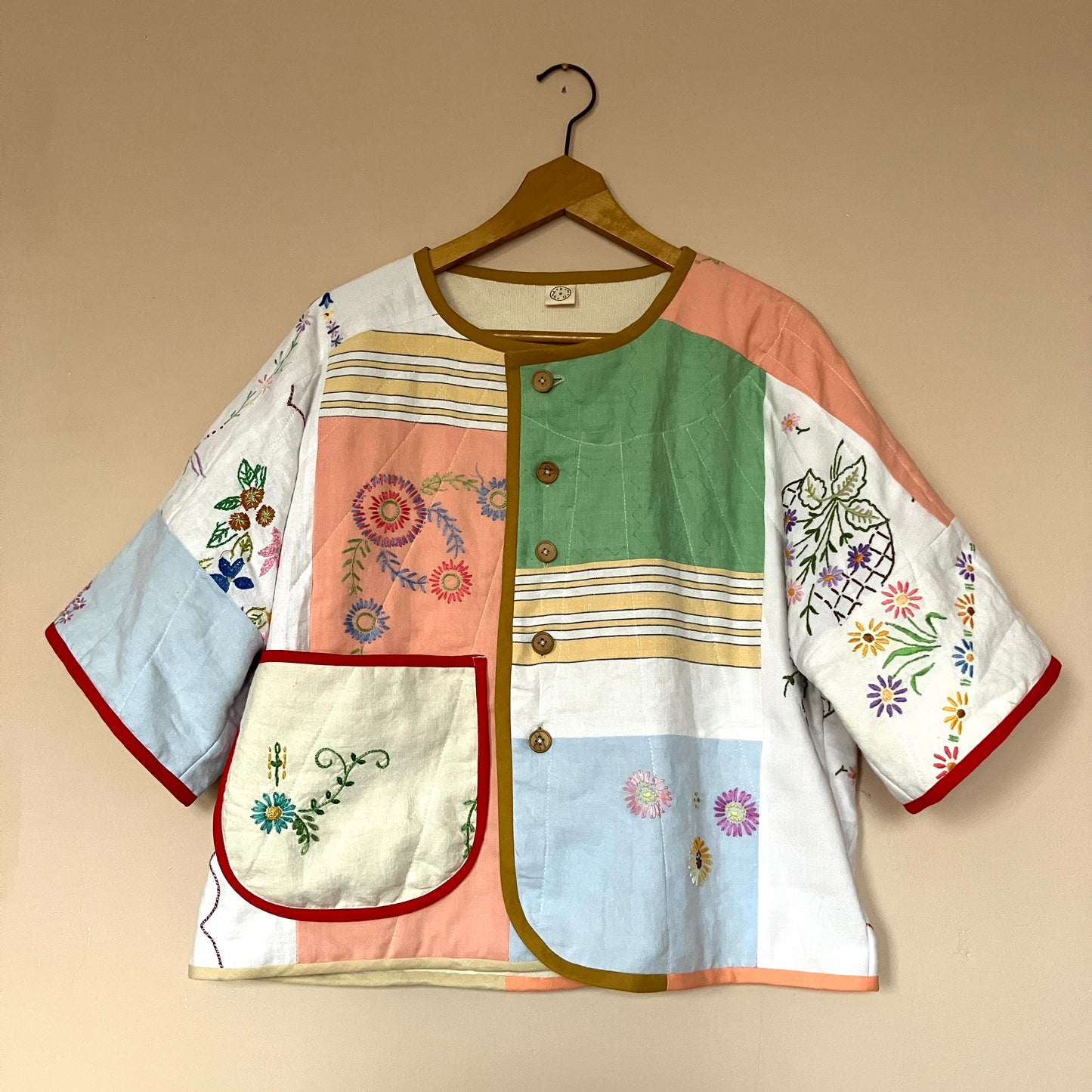 quilted top or jacket made from a patchwork of vintage tablecloths