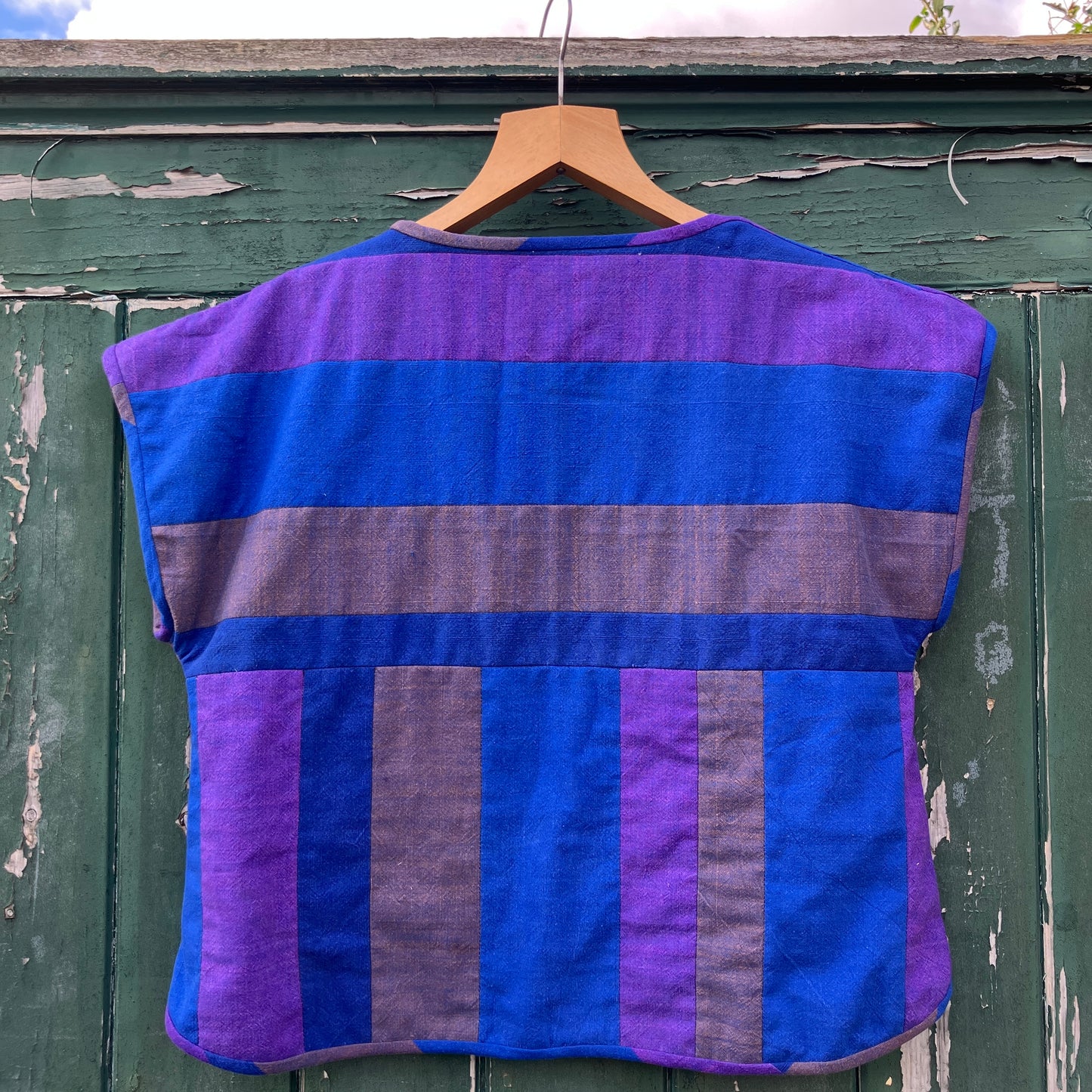 Blue and purple striped quilted top made from recycled fabrics, with a zip-up pocket