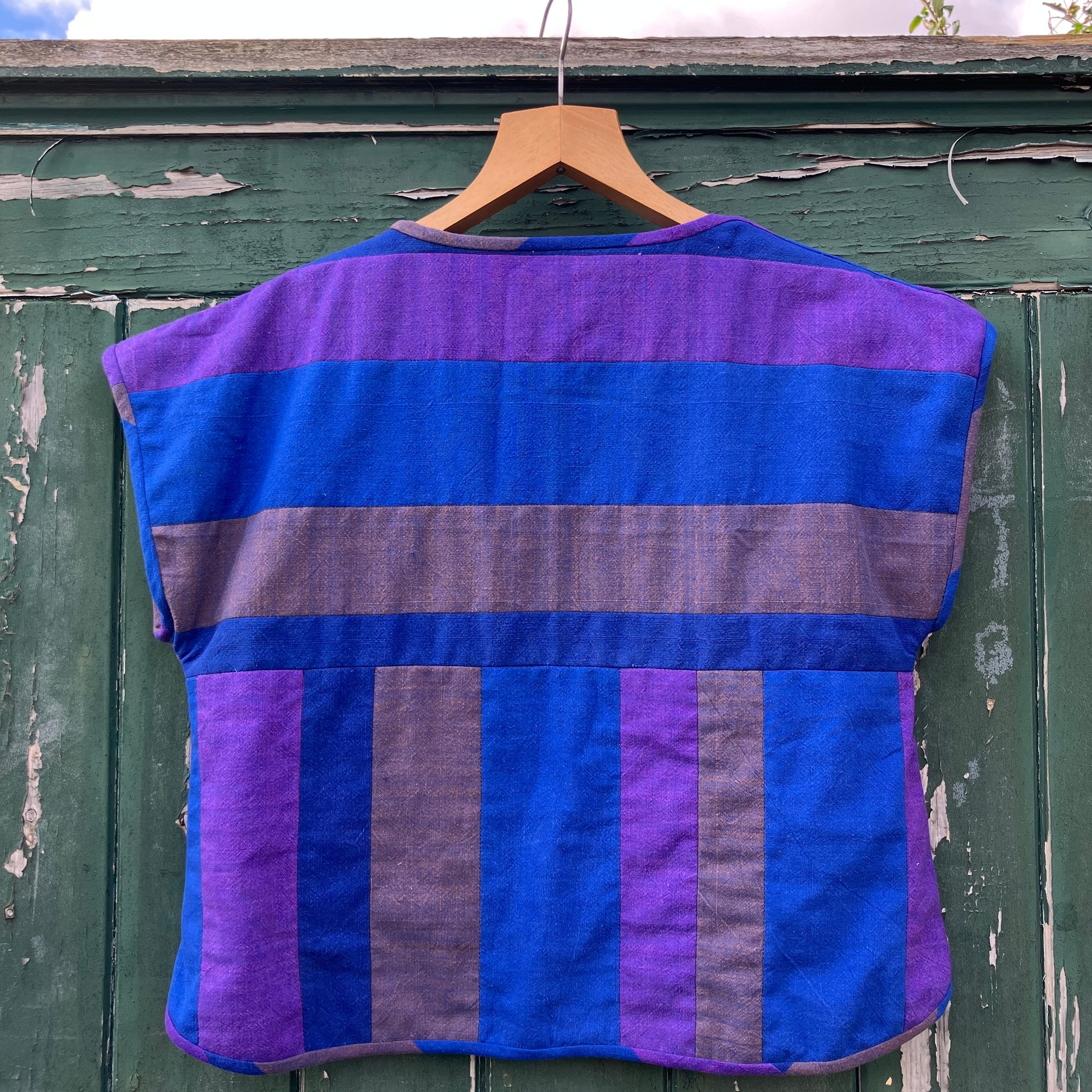 Blue and purple striped quilted top made from recycled fabrics, with a zip-up pocket